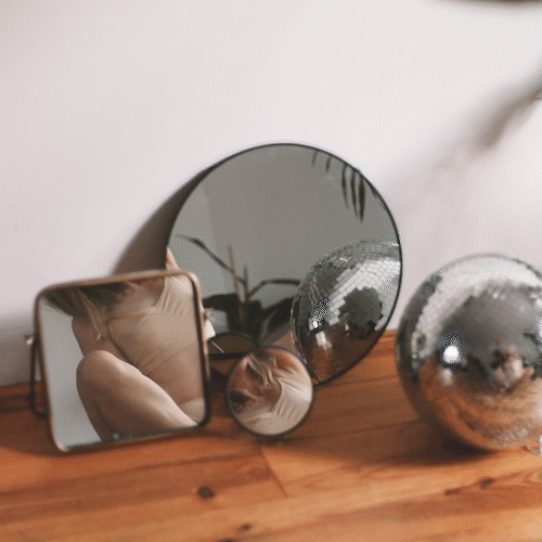 Collection of decorative mirrors on a wooden surface.