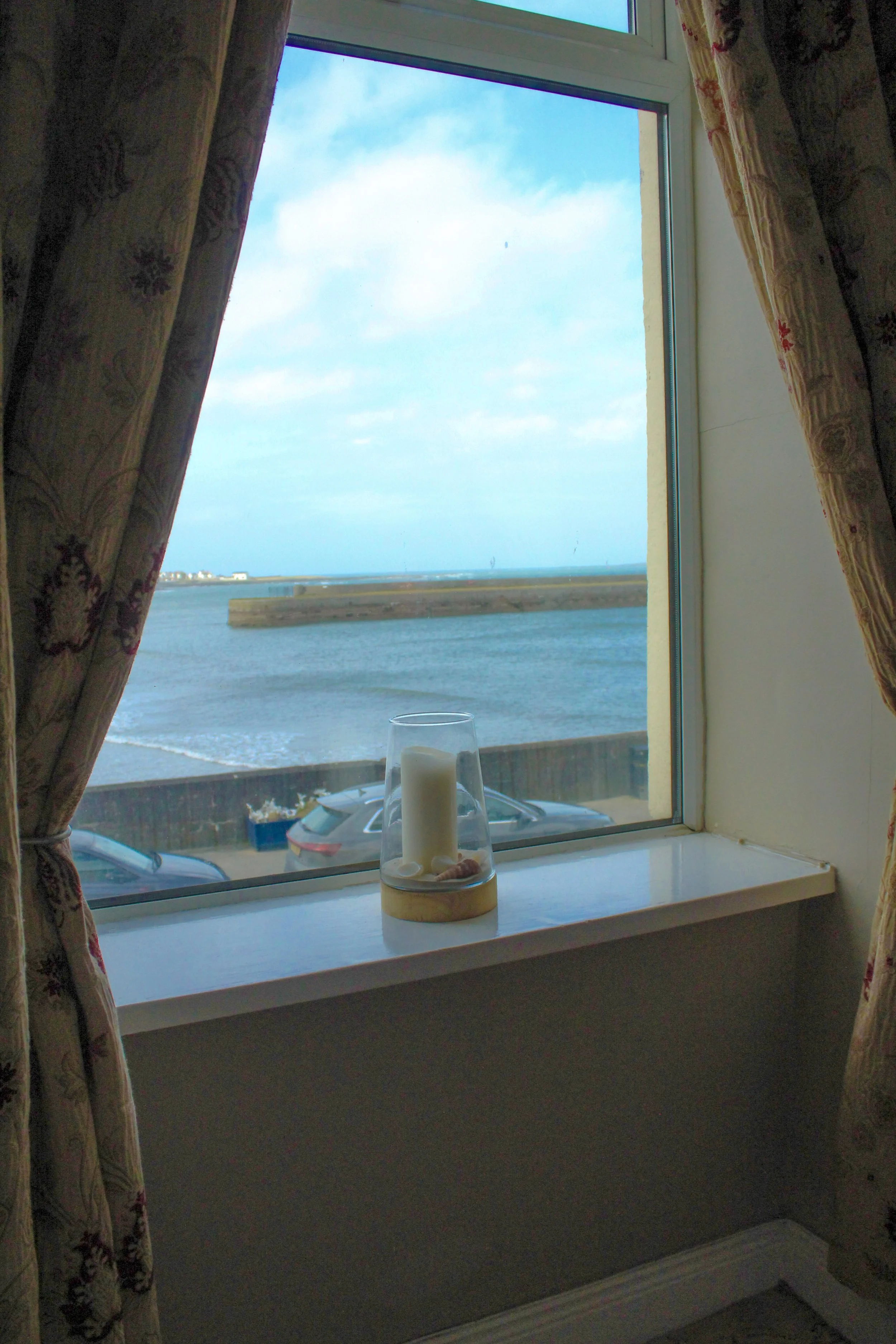 Sea views with a candle on the window sill.