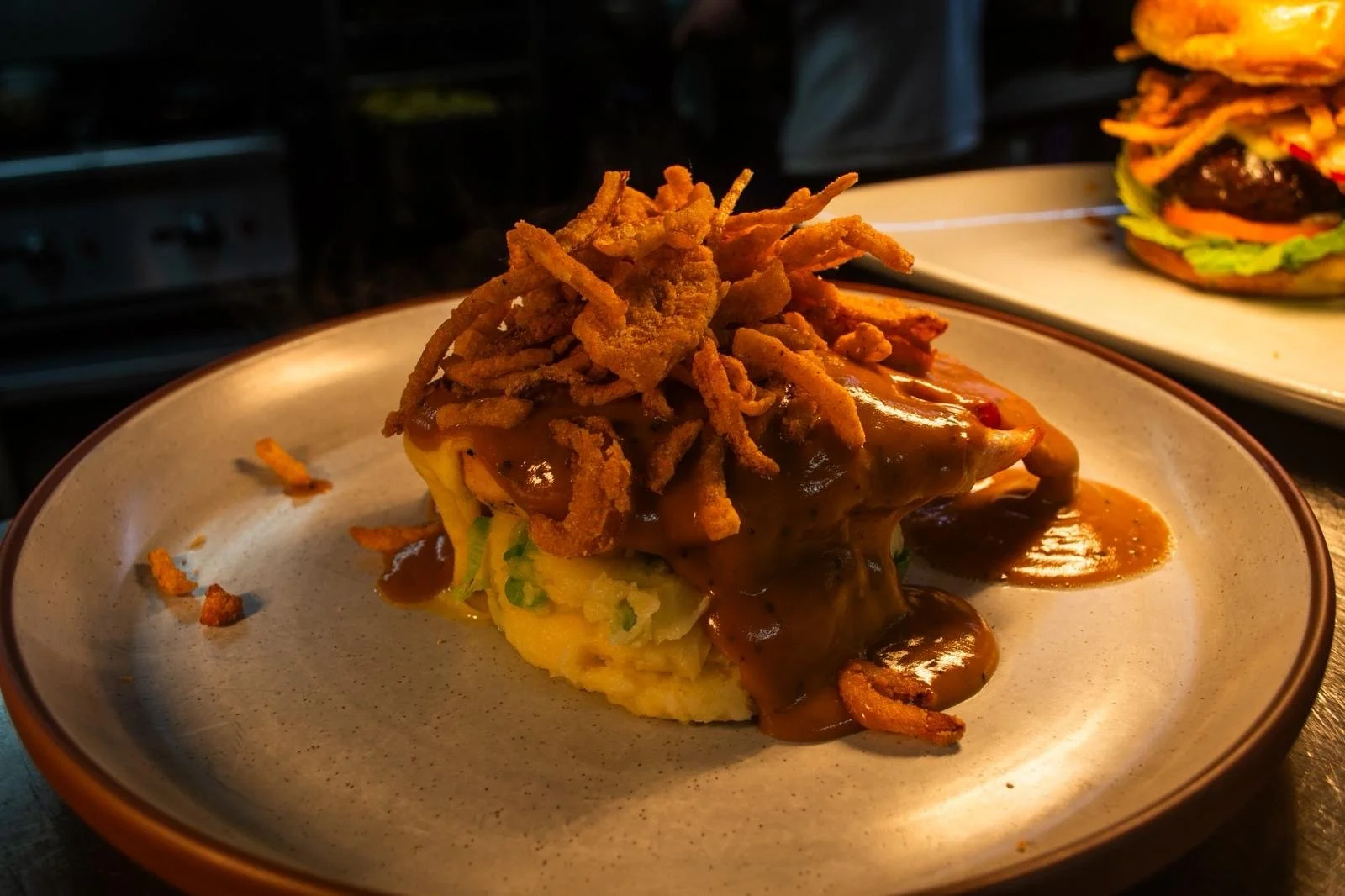 Chicken stack with pepper sauce, champ and tobacco onions