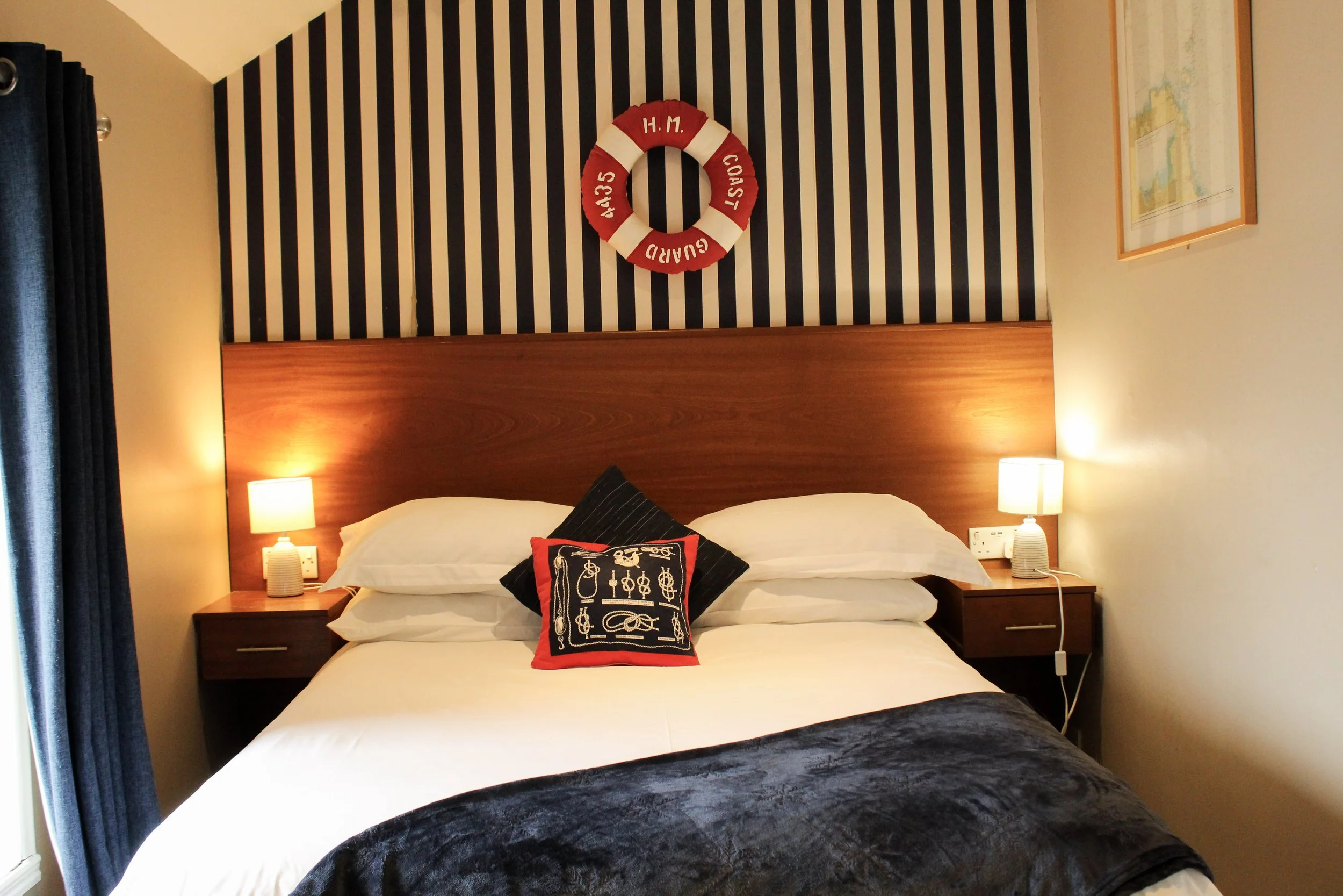 Image of Pier 36 guest house room with double bed, 2 lights and sea side themed decor.