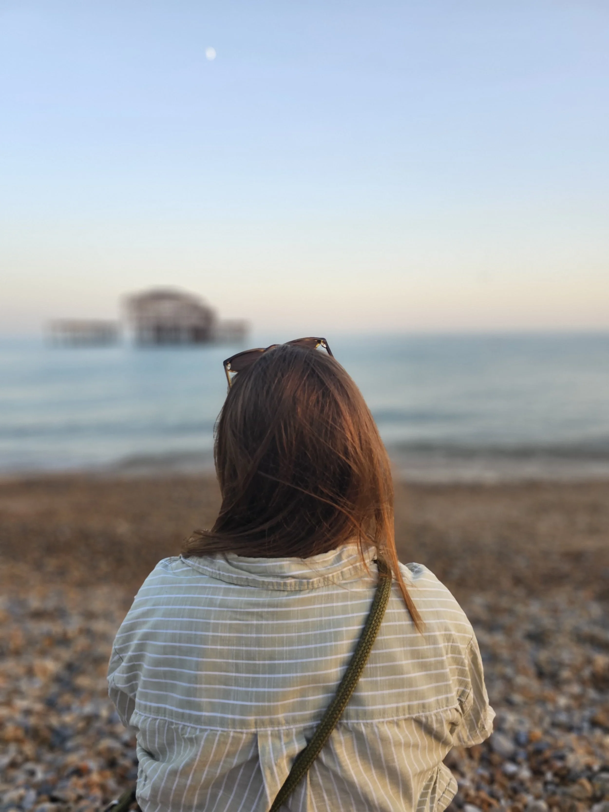 Interior designer Ieva looking at the old Brighton pier