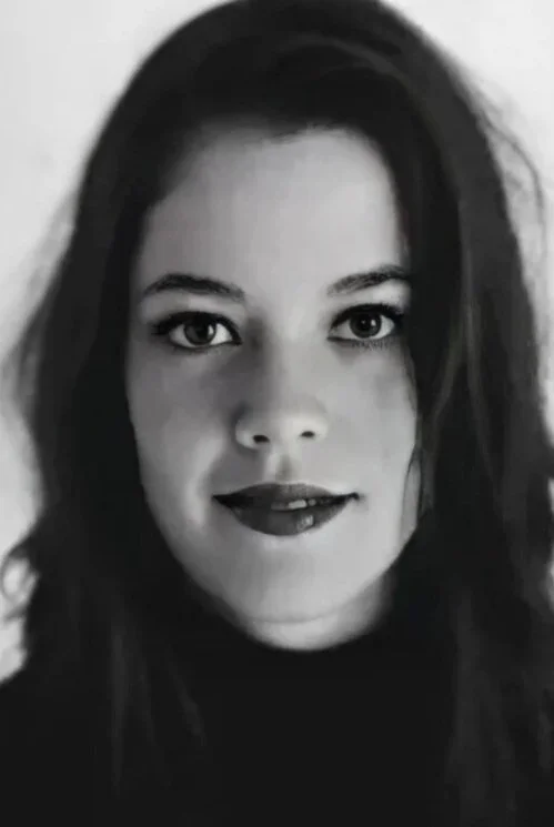 Schwarz-weiß-Porträtfoto von der Kölner Autorin und Künstlerin Julia Alina Kessel, die geradeaus in die Kamera schaut.