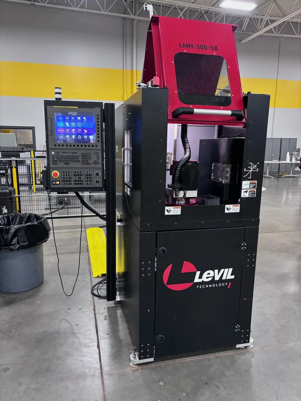 Industrial laser welding machine labeled 'Levil Technology' with control panel, in a factory setting.