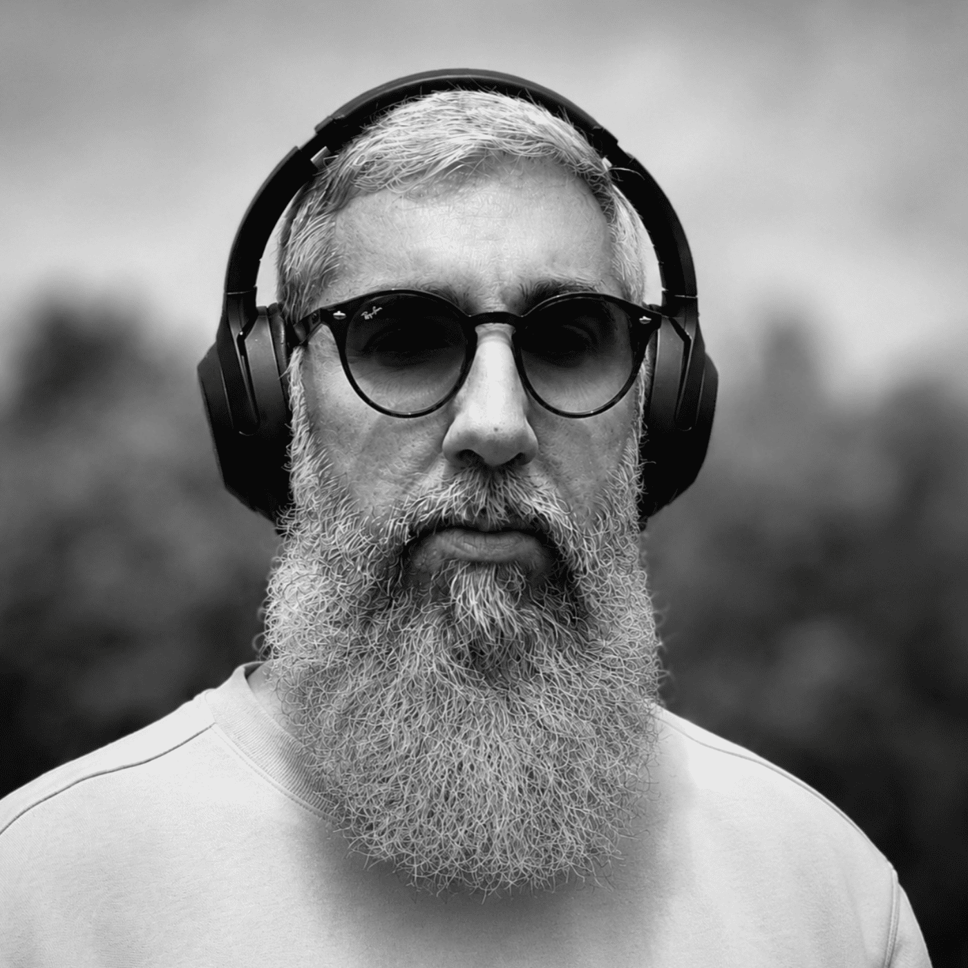 Portrait d'un homme arborant une barbe blanche et des lunettes de soleil