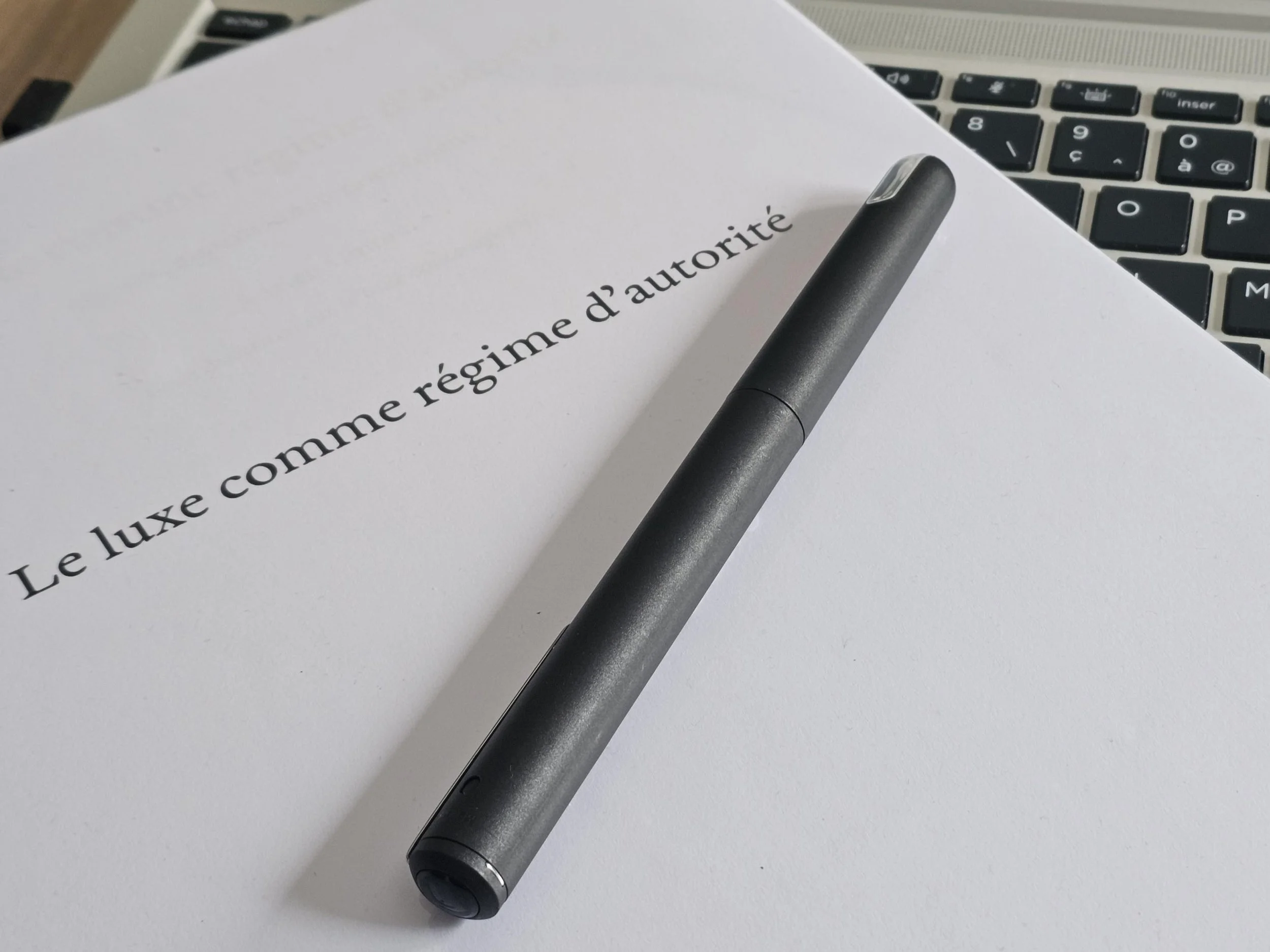 Un feutre posé sur un manuscrit parlant du secteur du luxe