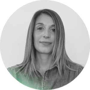 Ritratto di una donna con capelli lisci, che sorride leggermente, sfondo bianco e cornice circolare.