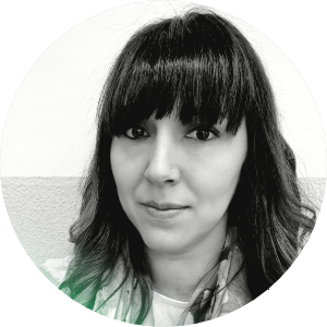 Ragazza con capelli ricci neri e frangia, sfondo bianco e muro decorativo