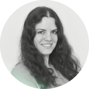 Sorridente donna con capelli ricci in uno sfondo bianco e rotondo.