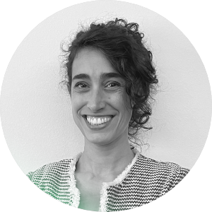 Foto in bianco e nero di una donna con i capelli ricci e un sorriso, sfondo bianco