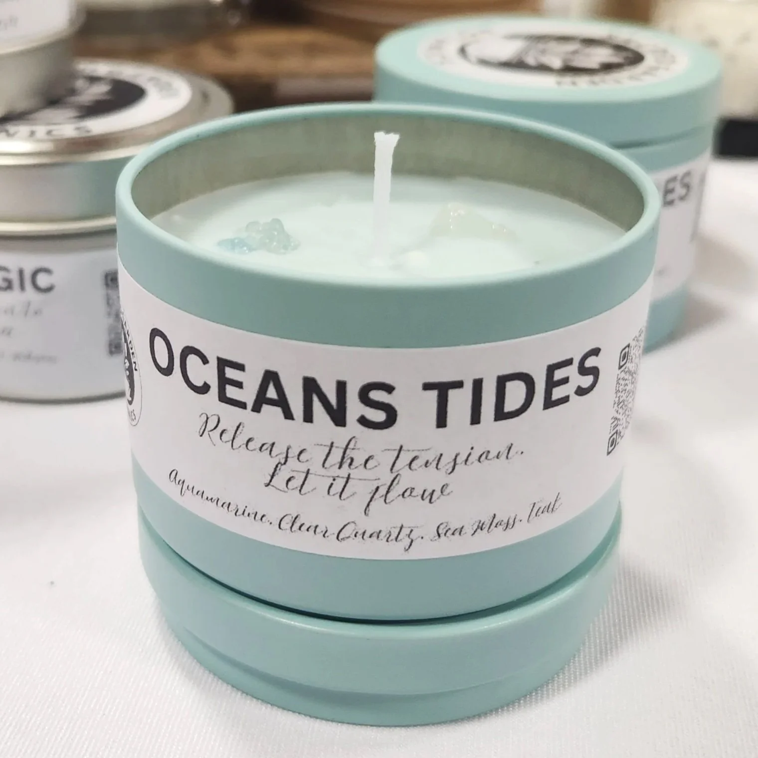 Picture of 4oz Oceans Tide candle, in light aqua blue container with light blue wax and aquamarine crystals on top.