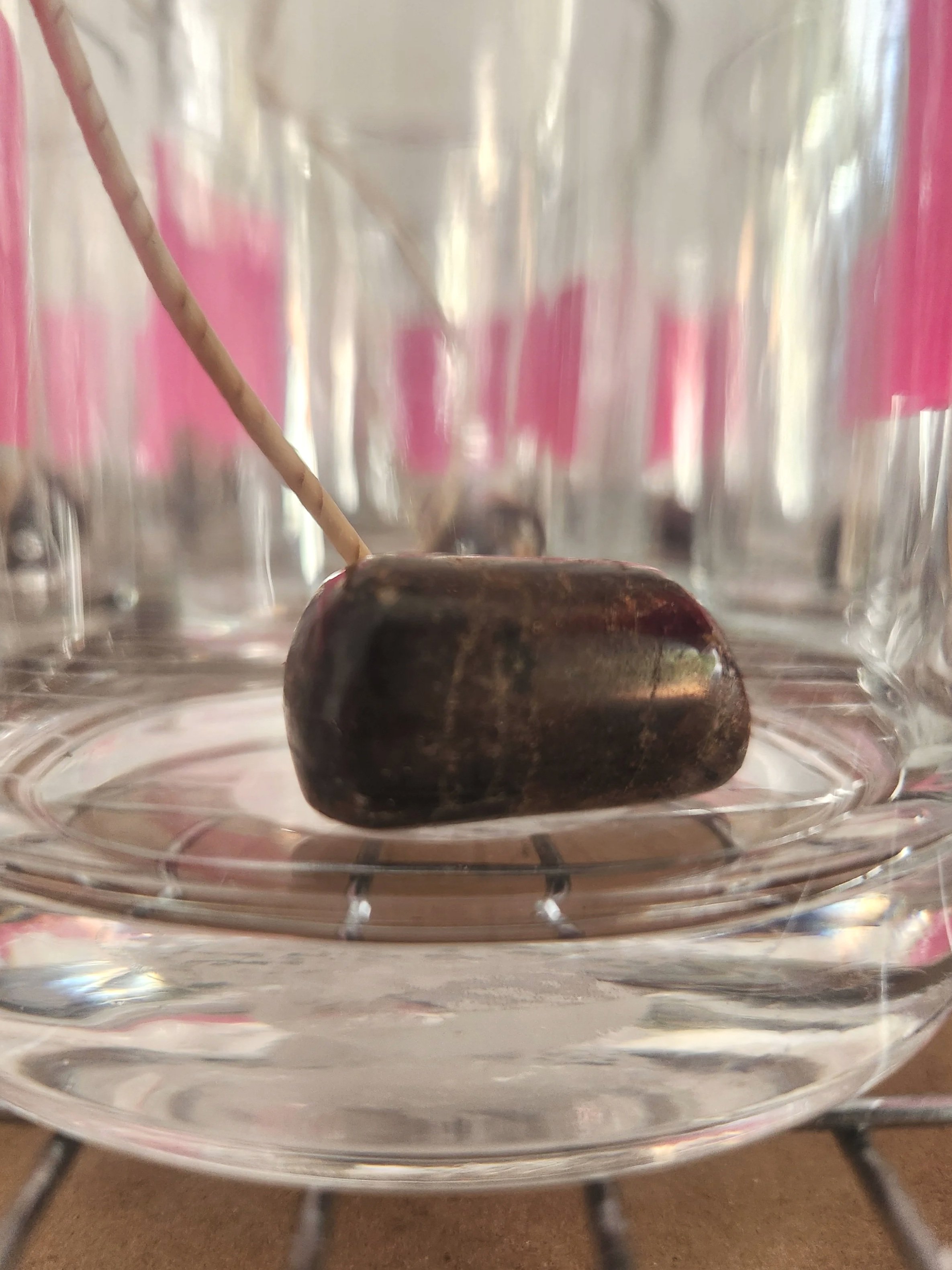 Close up image of a garnet in the bottom of a 9oz candle container