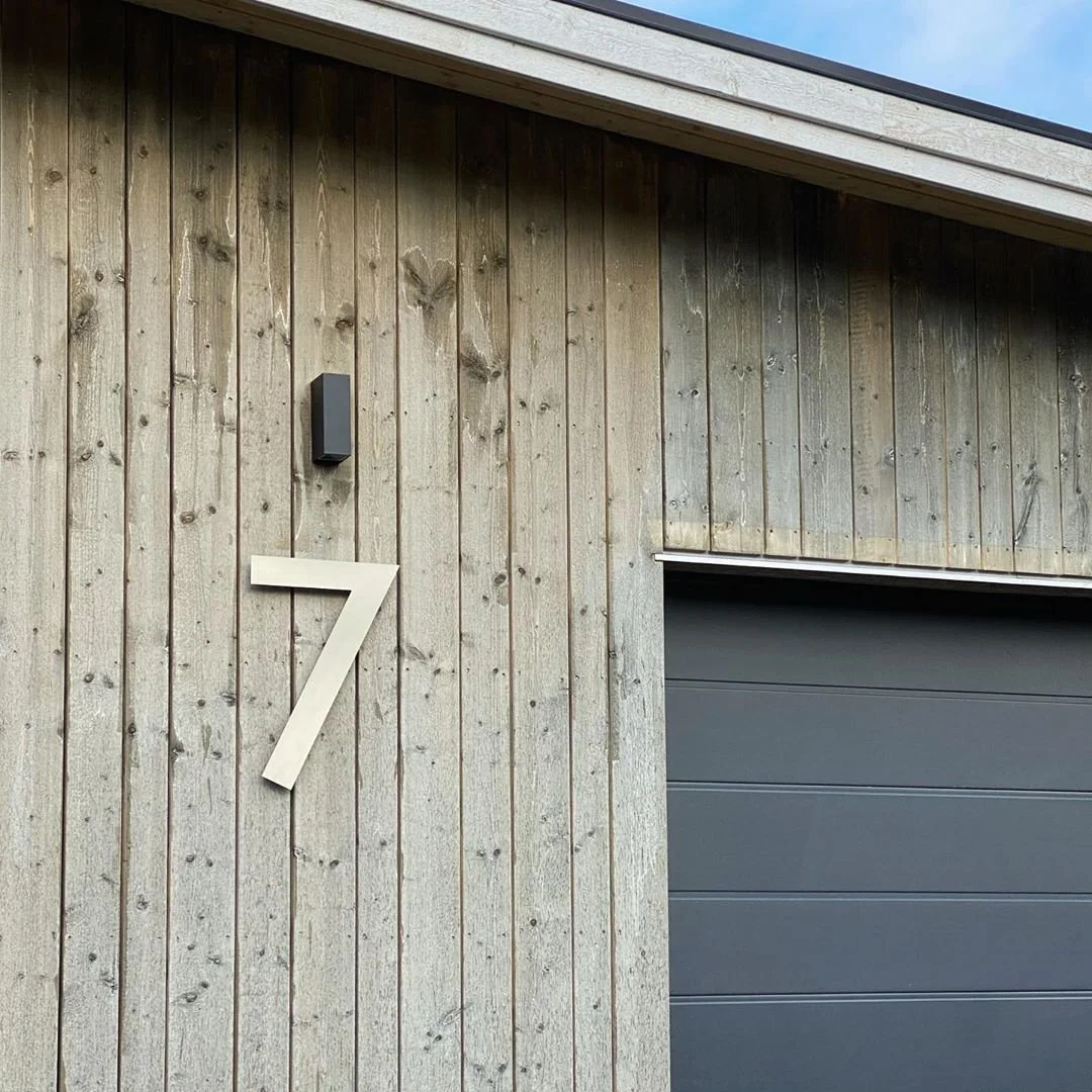 Husnummer 7 i plywood på träfasad