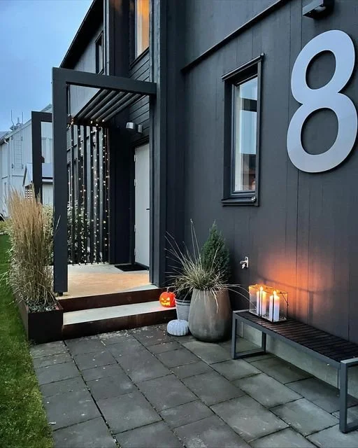 Moderne hus med husnummer 8 på mørk træpanelfacade – stilren indgang