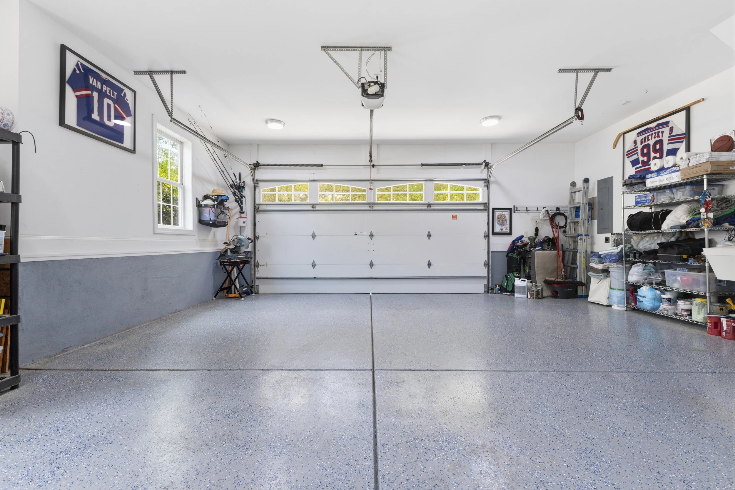 Empty garage with organized shelves and sports memorabilia on the walls.