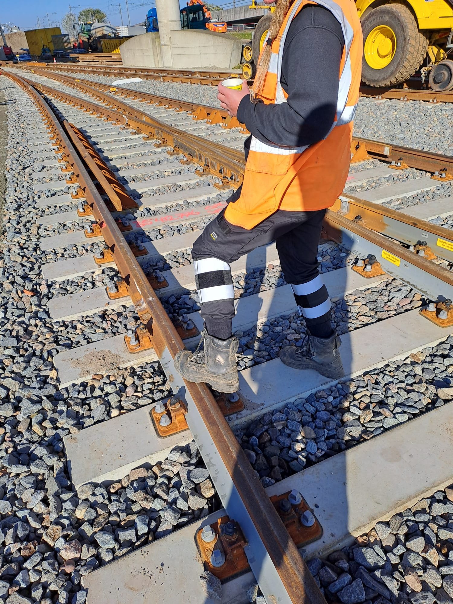 Close-up van RefLegs reflecterende beenbanden gedragen door werknemer die rails opmeet