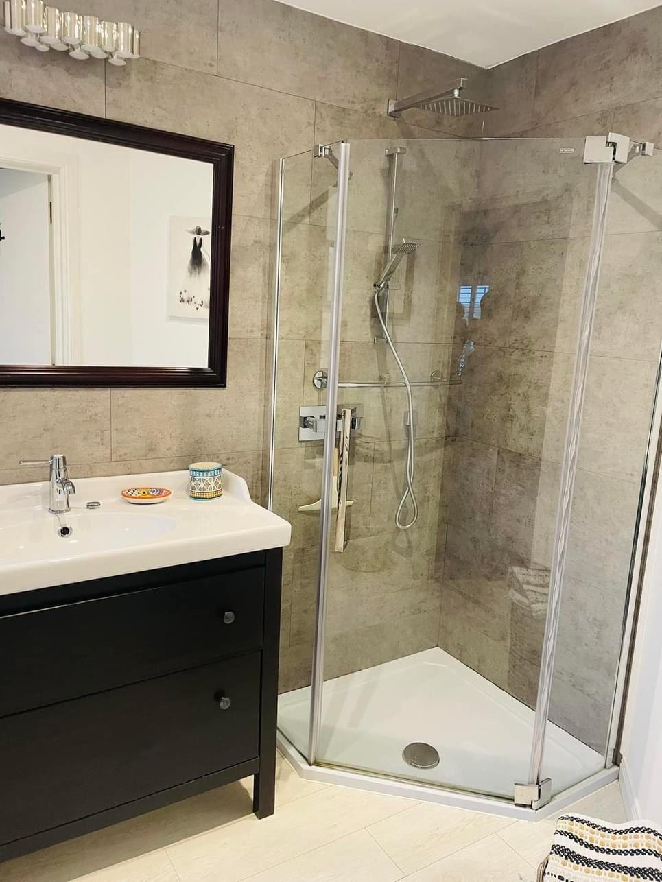 A bathroom with a vanity, mirror, and a glass shower enclosure.
