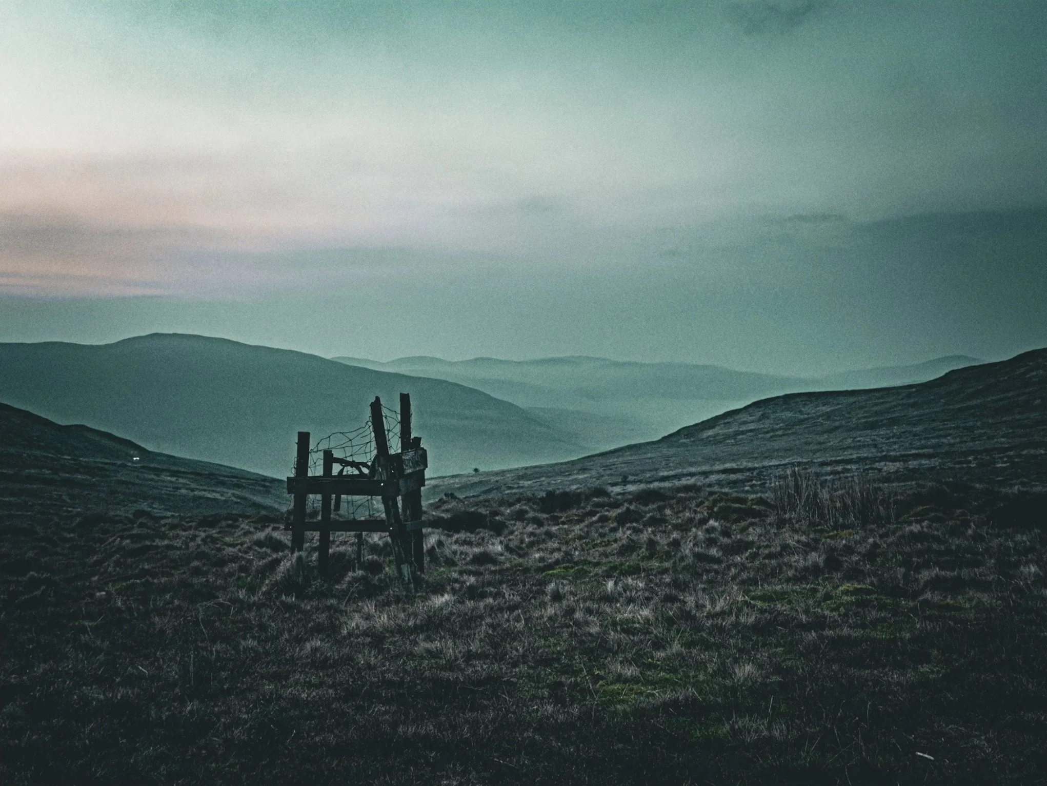 Broken+post+against+misty+layered+hills.jpg