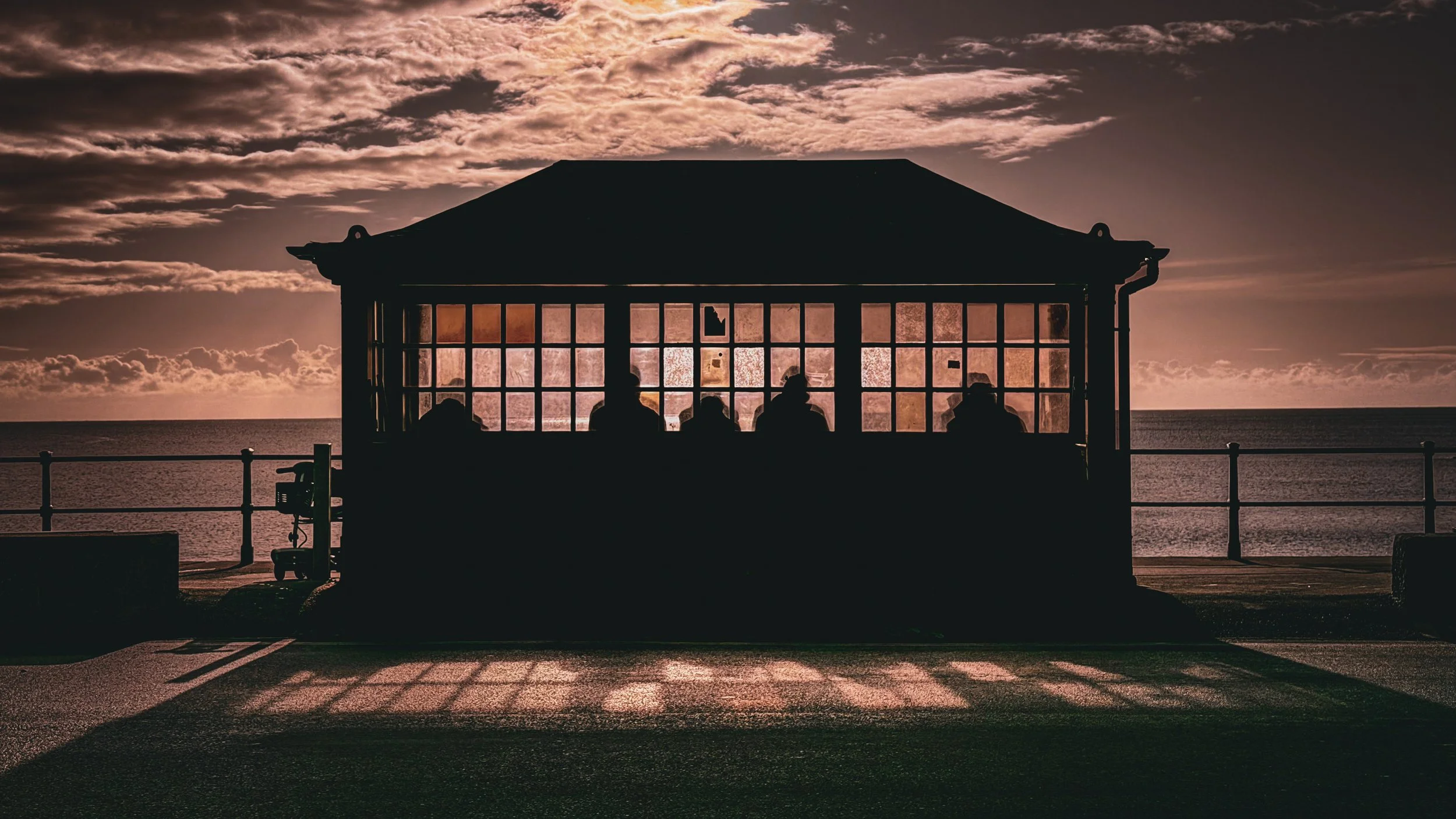 Seafront shelter silhouette with figures inside.jpg