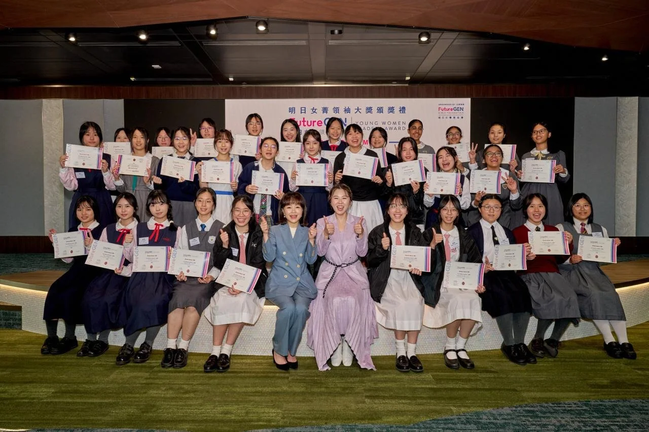 Group of young women and girls holding certificates at an award ceremony, smiling and making victory signs, with a banner in the background that reads 'Future GEN' and 'Young Women Leadership Award' in English and Chinese.