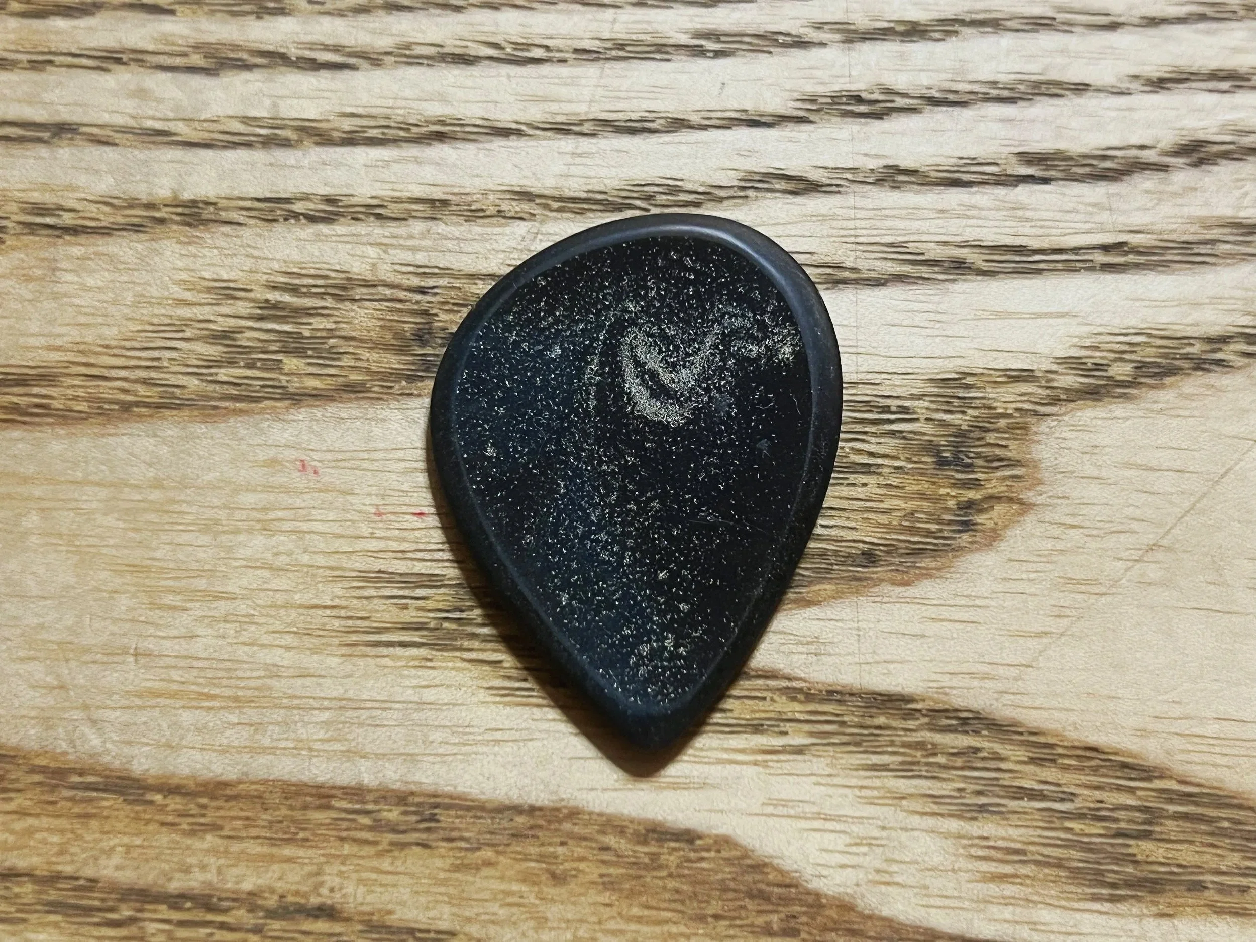 Close-up of a black hockey puck on a wooden surface.