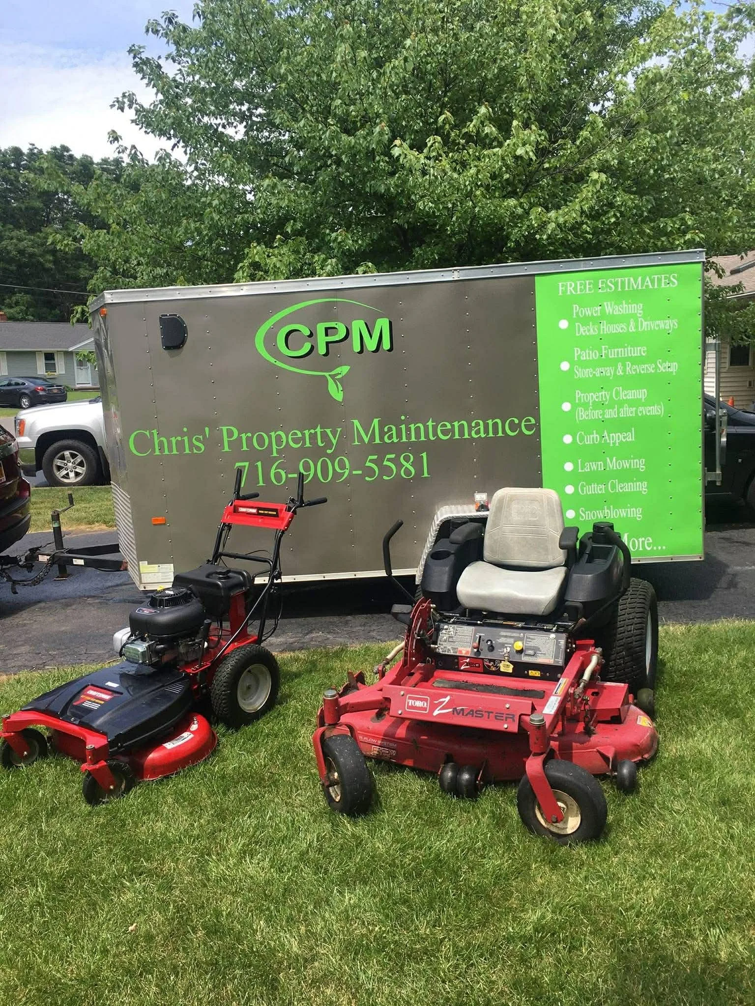 A mobile property maintenance service trailer with the name 'Chris' Property Maintenance' and phone number, parked on a grassy area. Two lawnmowers, one riding and one push, are positioned in front of the trailer.
