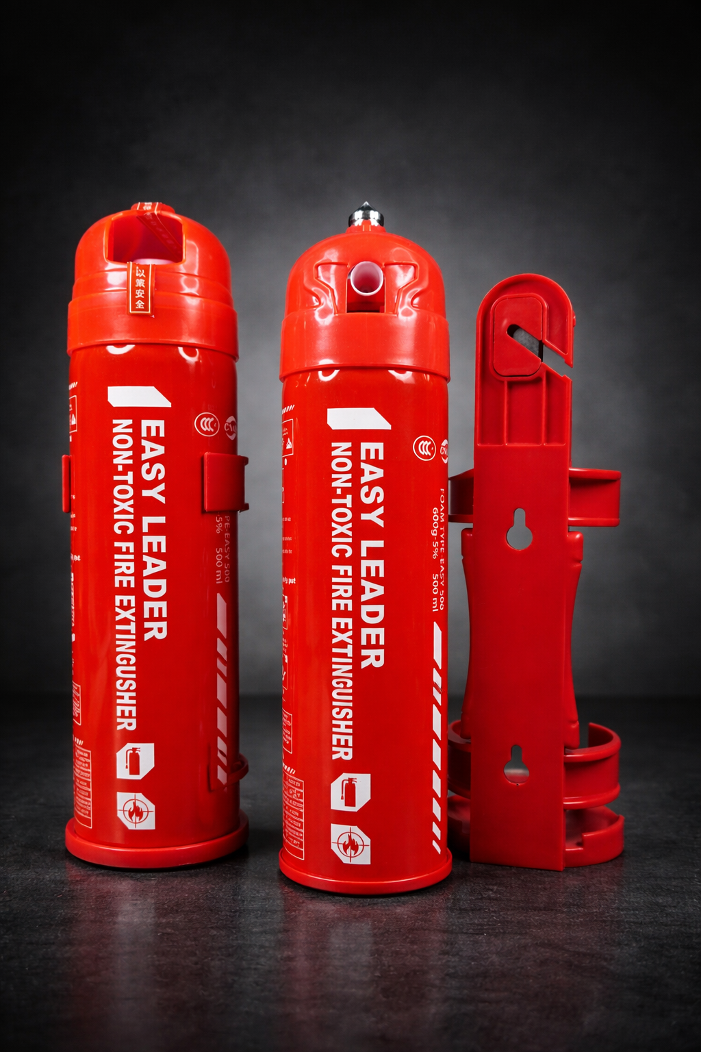 Three red fire extinguishers placed on a dark surface against a dark background.