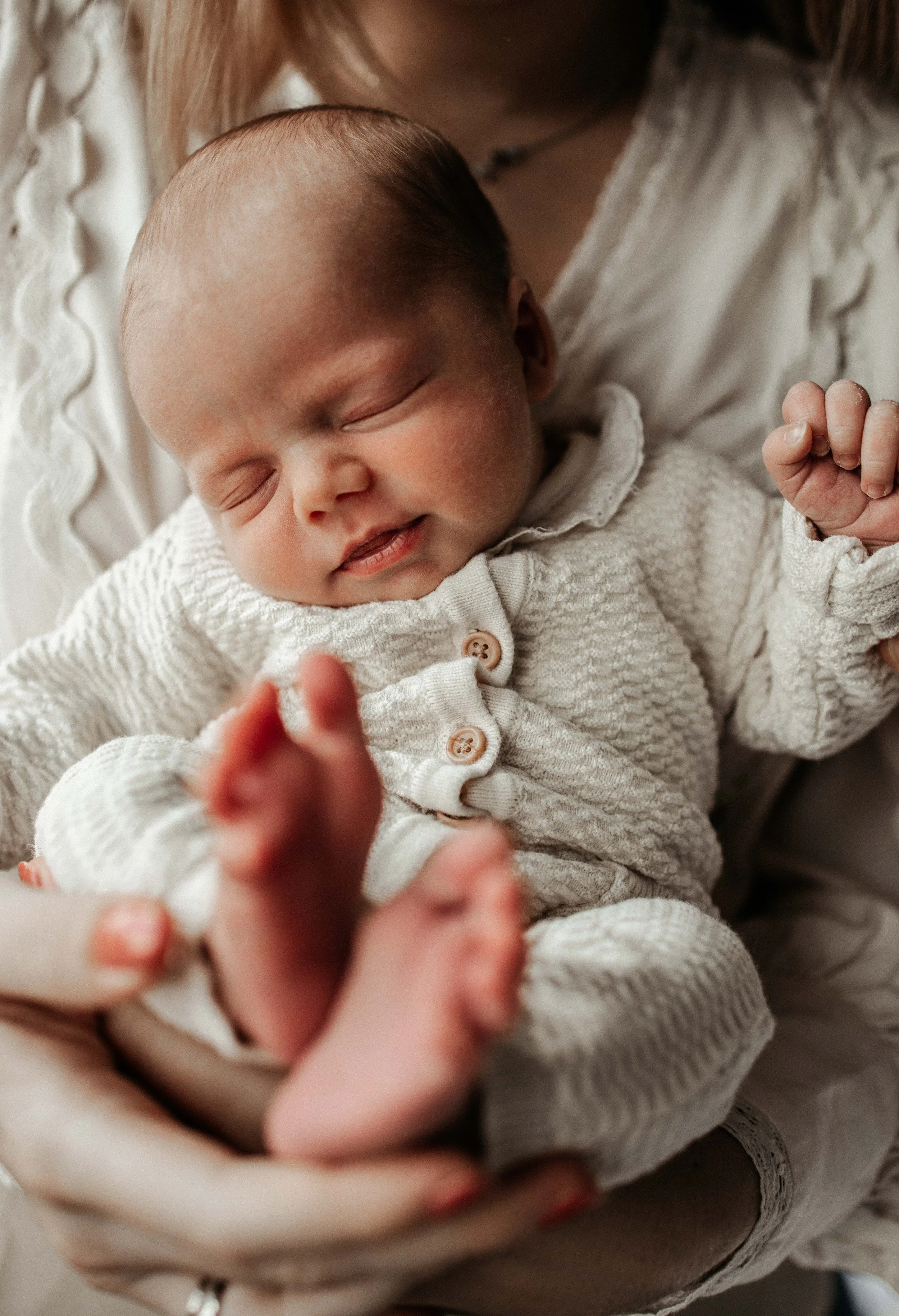 Foto van een pasgeboren baby in een gebreid pakje
