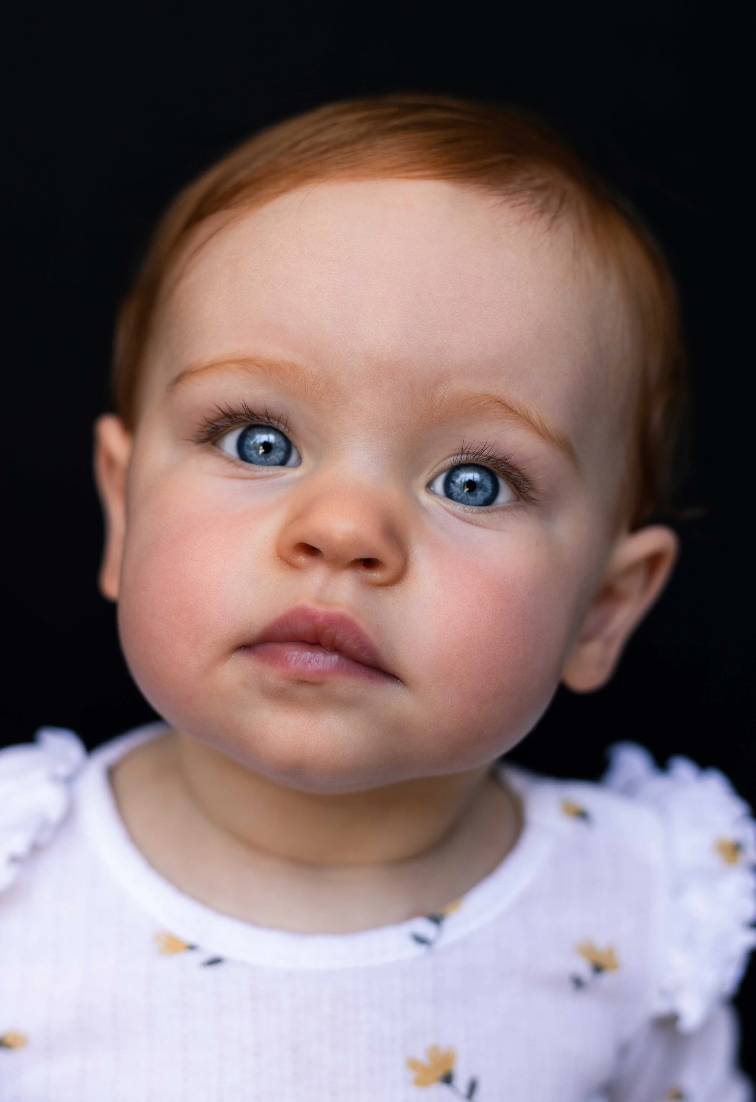 Kinderportret van een baby met rood haar en blauwe ogen