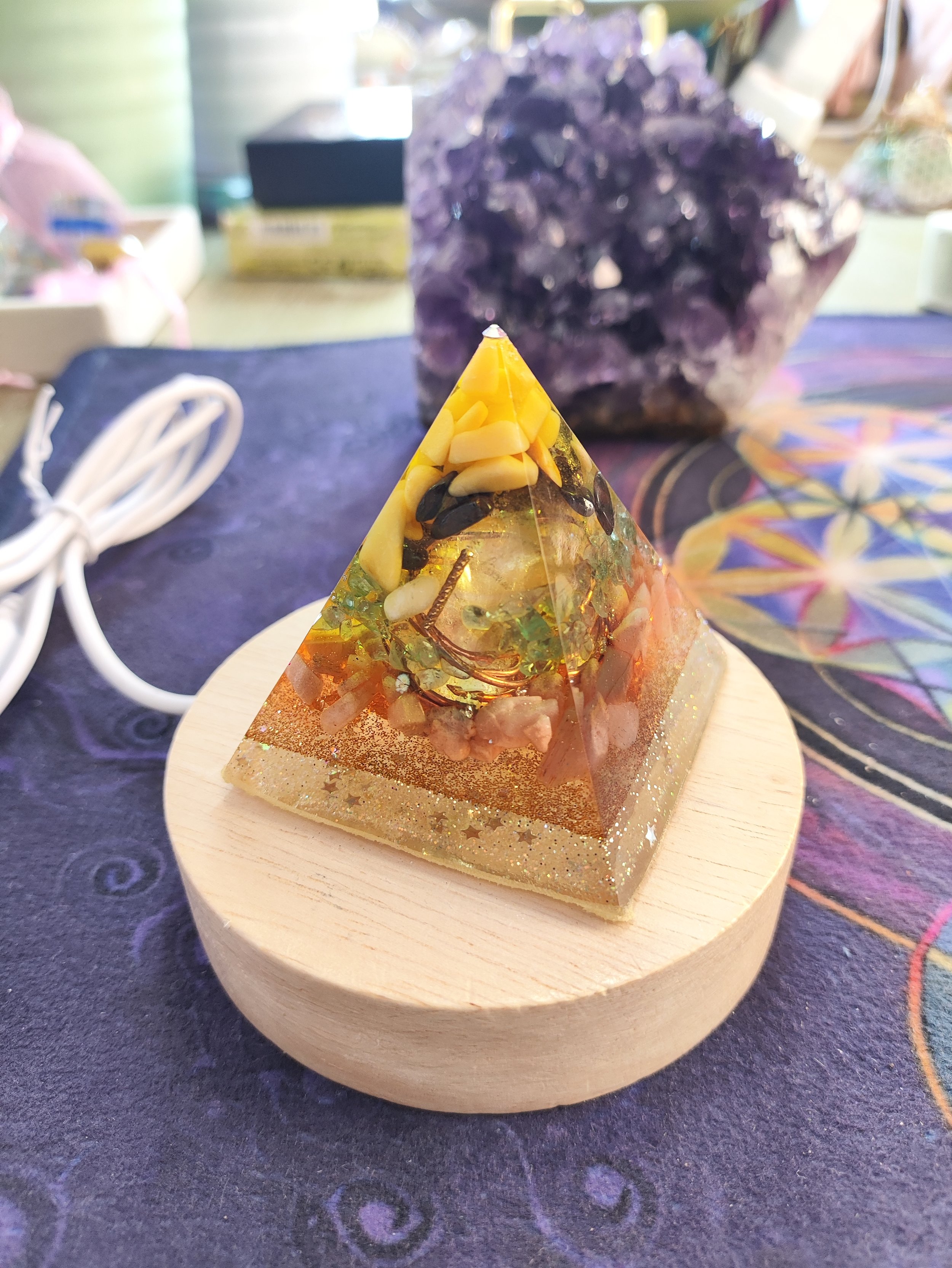 Orgonite pyramide sur lumieres de couleurs