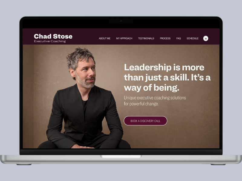 Laptop displaying a coaching website for Chad Stose, featuring a portrait of a man with gray hair and beard, wearing a black jacket, with text about leadership and a booking button.