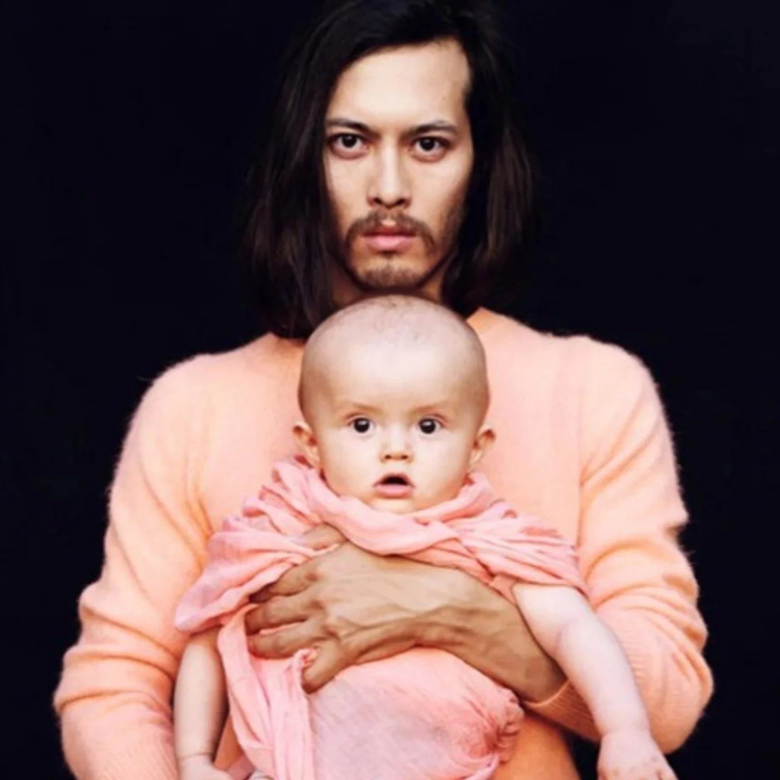 Coral by Unilever campaign image: a man in a peach sweater holding a baby wrapped in pink