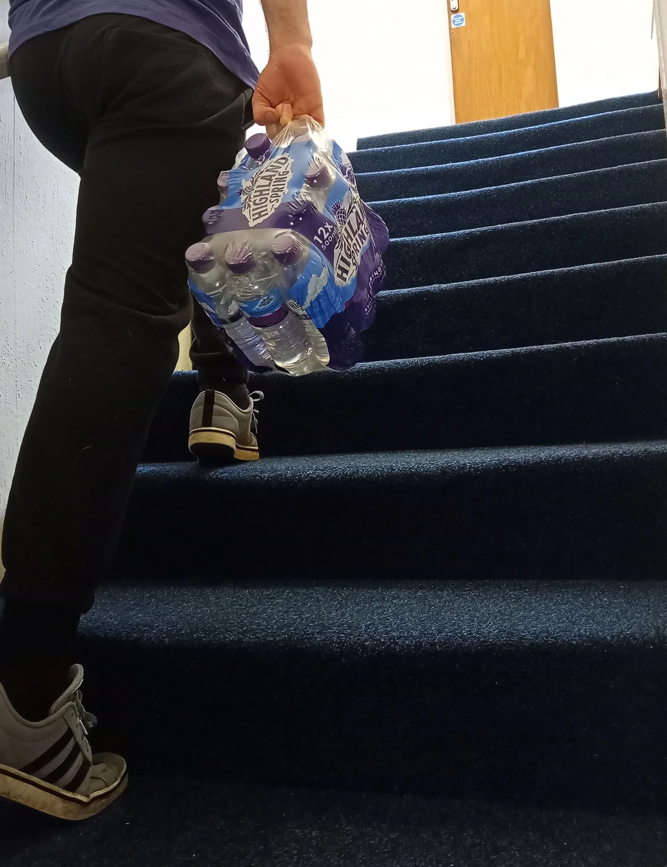 Ross carrying water bottles upstairs during an everyday movement task