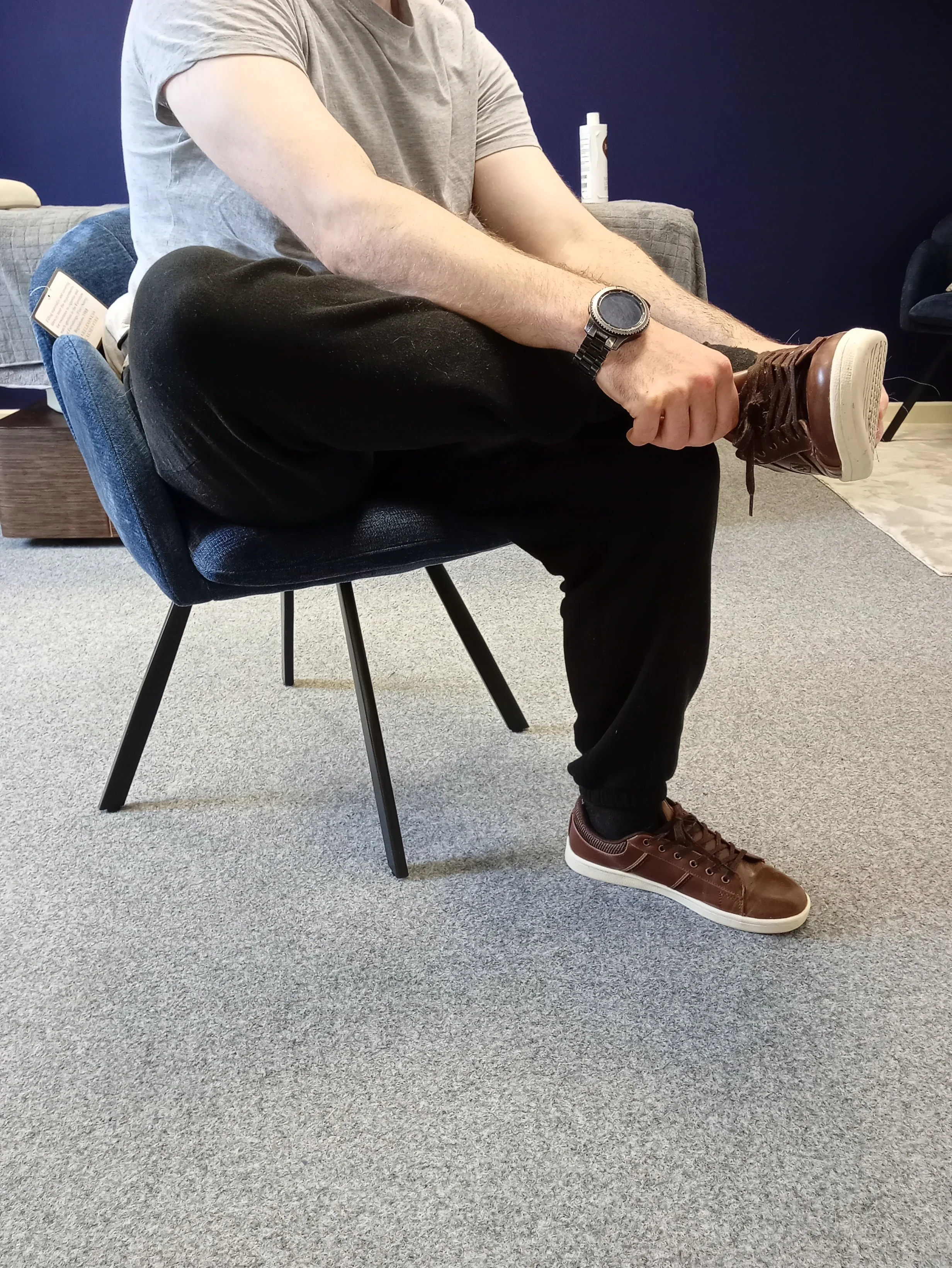ross flexing in seated position to put shoes on