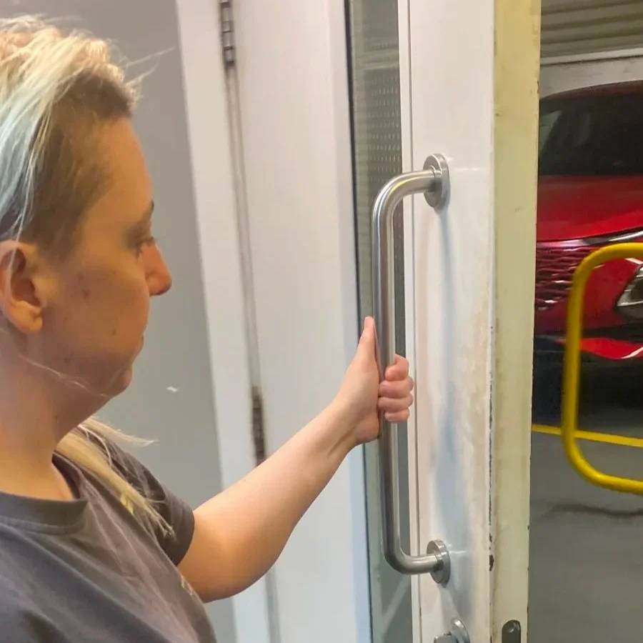 Paula pulling open a door showing how msk system is used in everyday life