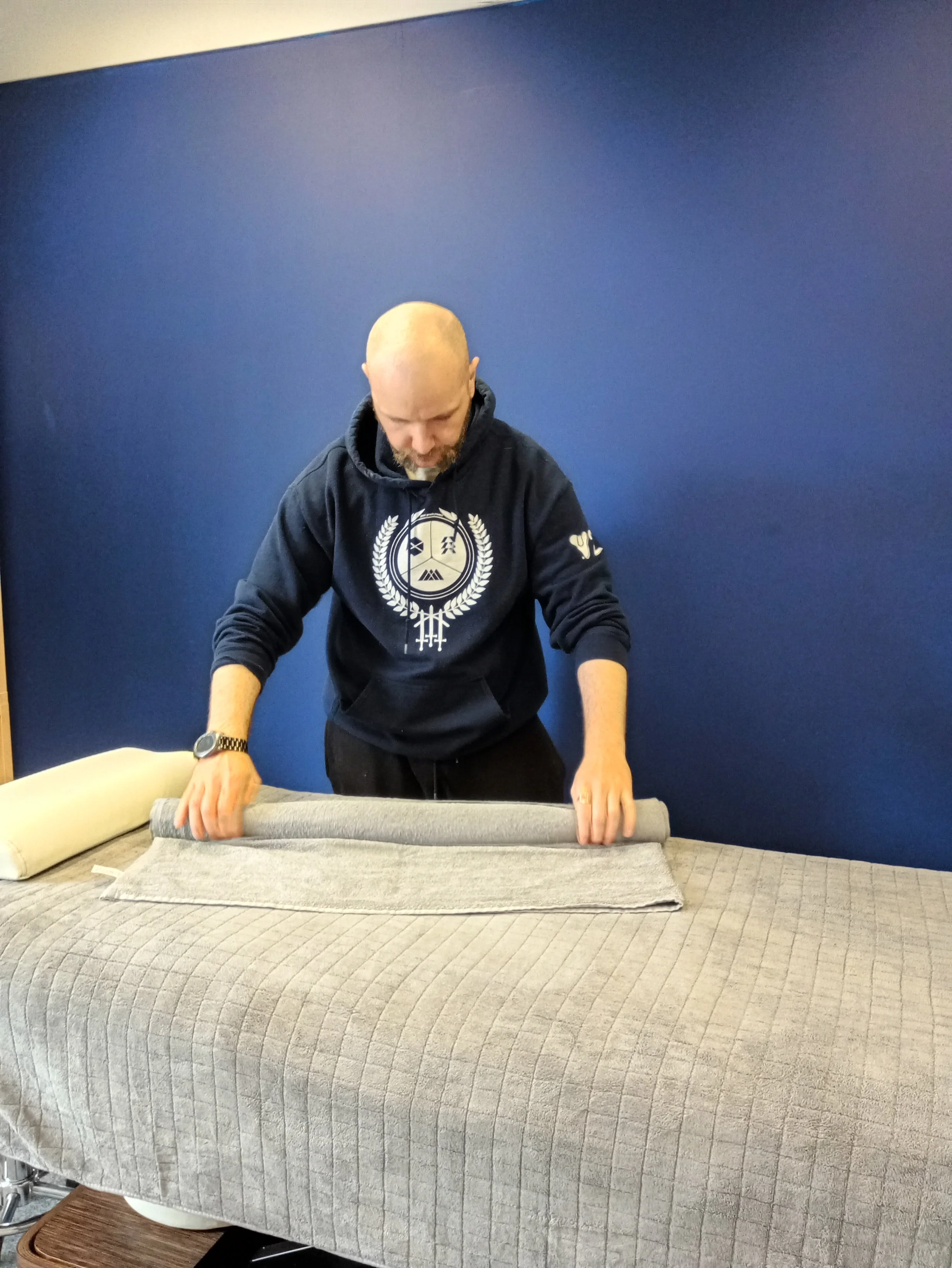 image of male msk therapist setting up treatment area