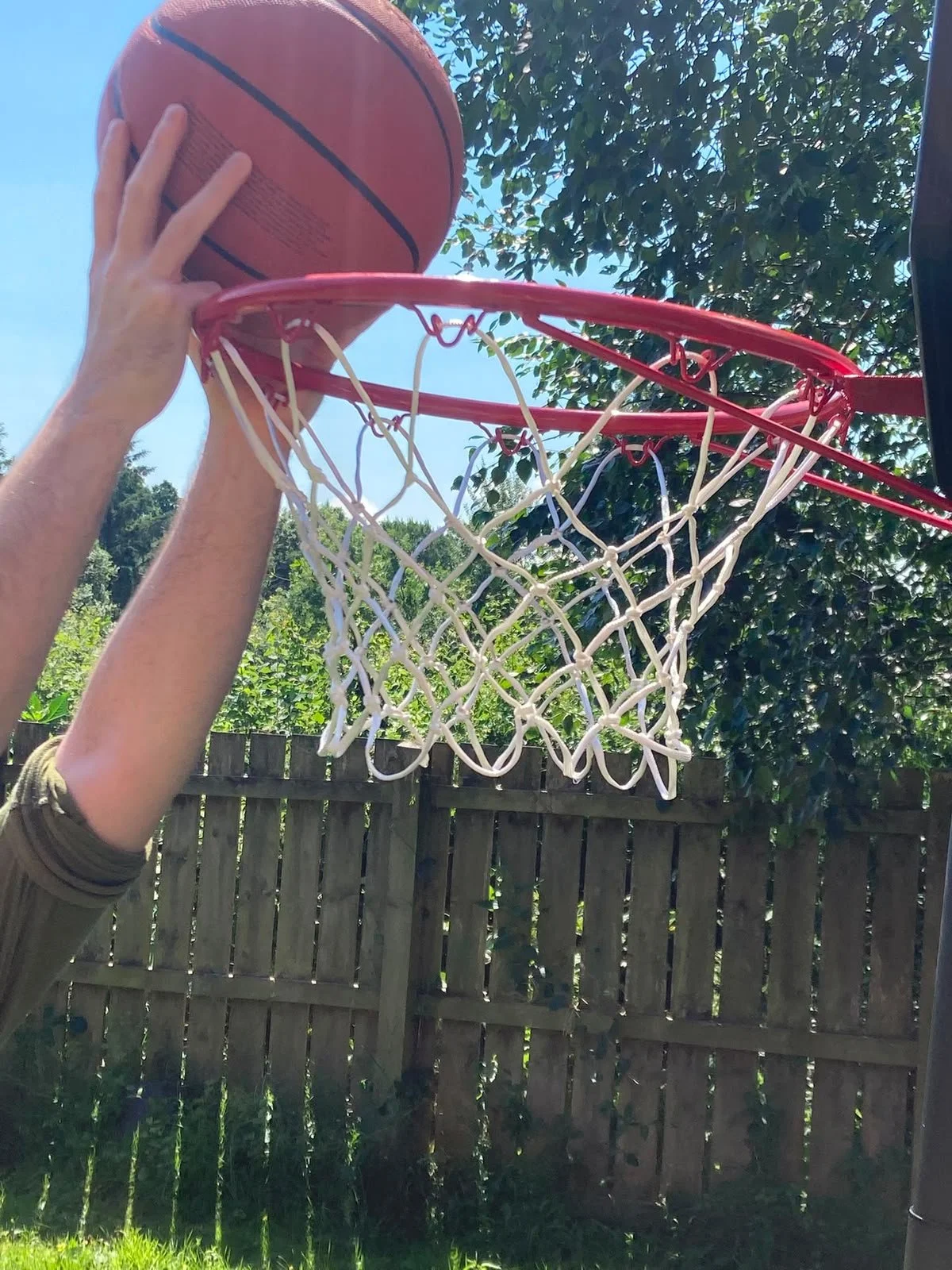 ross dunking basketball in his garden playing with children for recreational sporting fun