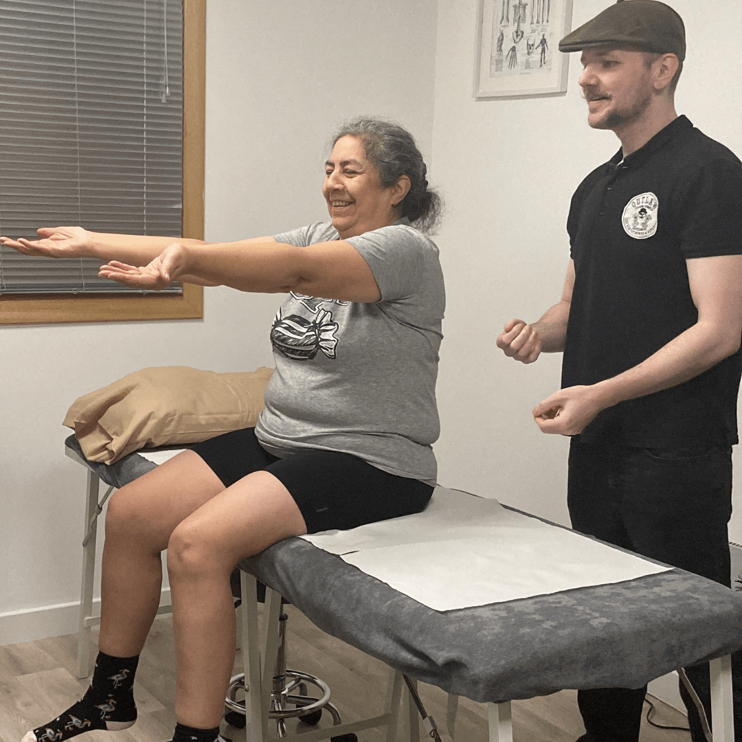 sports therapist doing post treatment checks on elderly ladies bicep injury with happy results