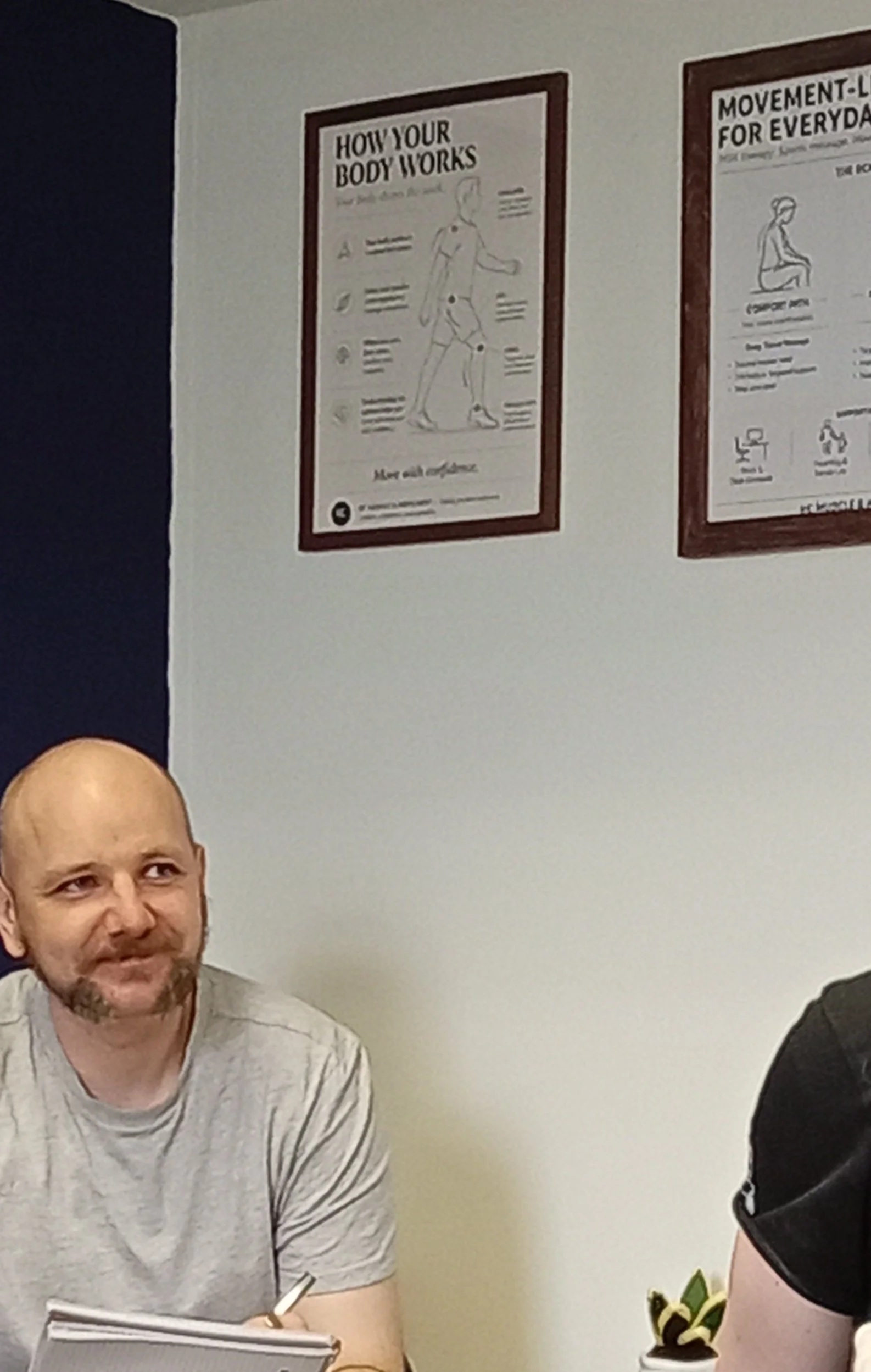 Ross Canning speaking with a client after massage and discussing how the treated area feels following the session.