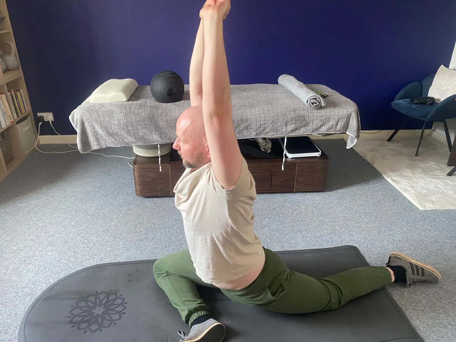sport therapist Ross demonstrating a stretch in clinic holding a pose showing what may be in a session