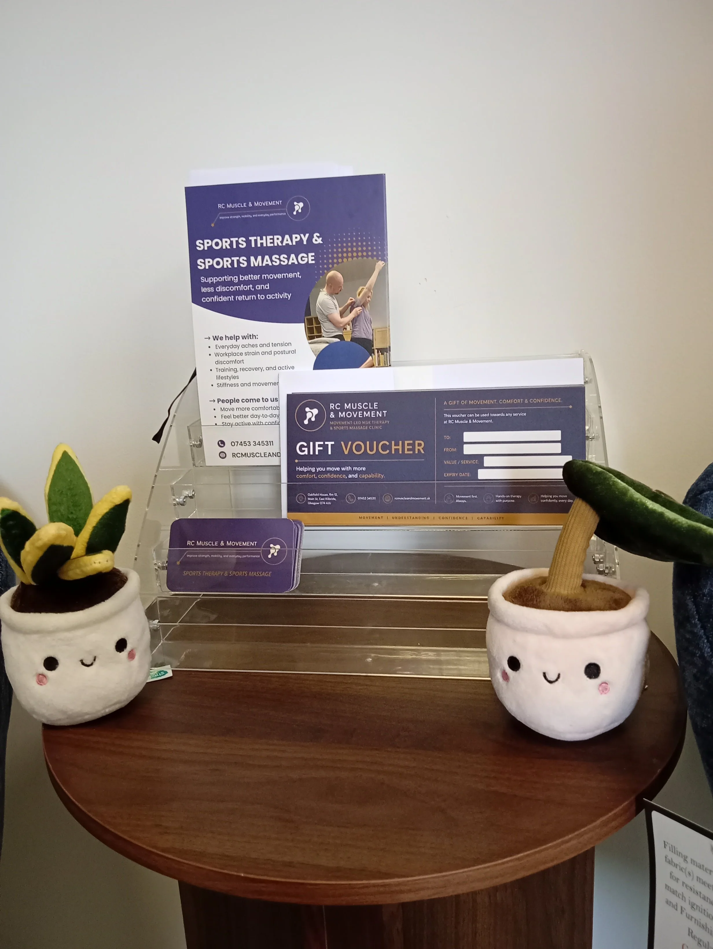 image of display on table within RCMM clinic in East Kilbride showing vouchers , flyers and business cards
