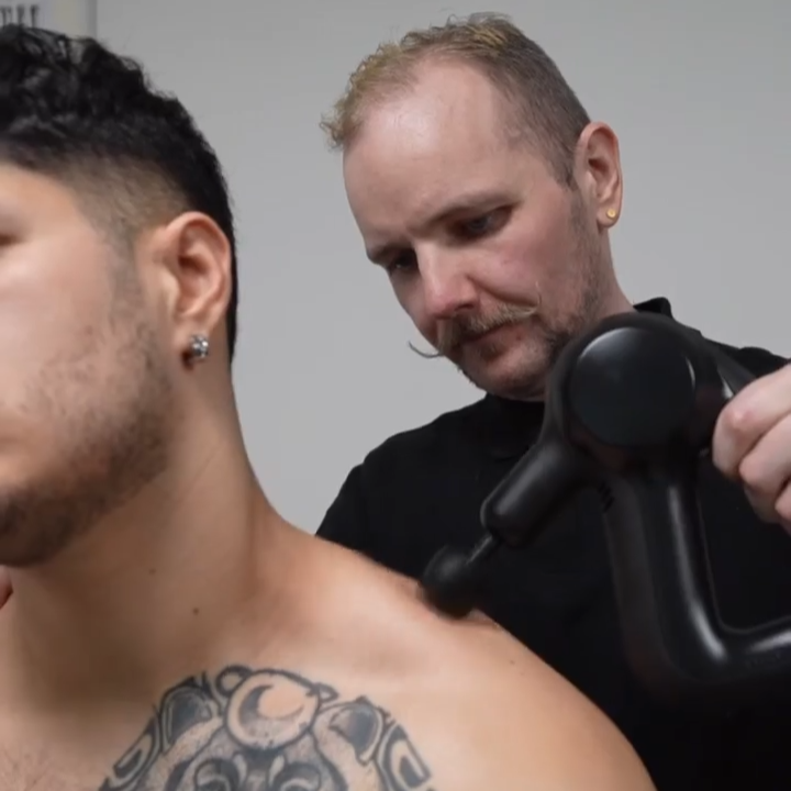 Ross Canning using a massage gun during a Sports Massage appointment