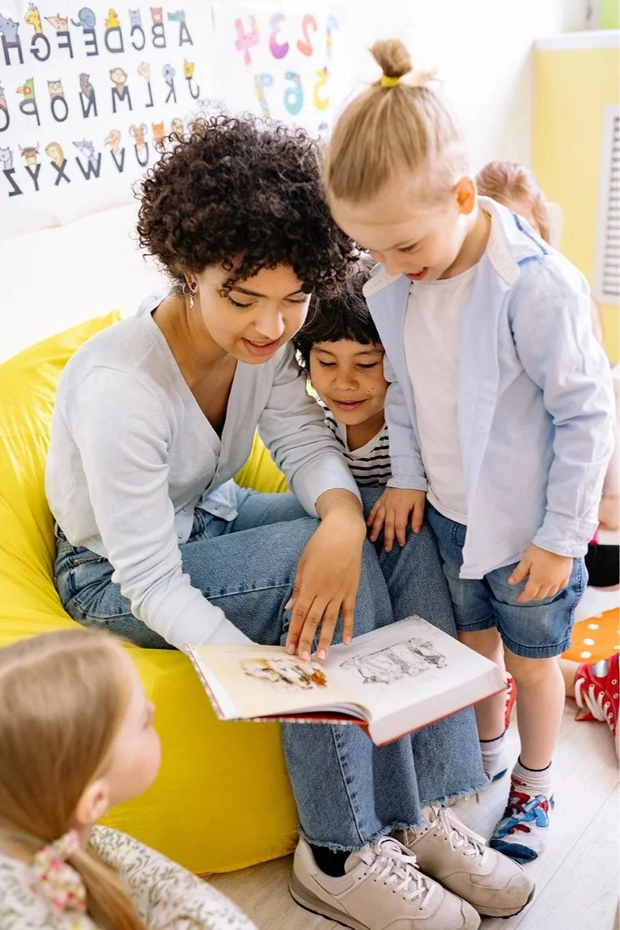A contract speech therapist in Washington State reading a book to children in a classroom to help with language skills.