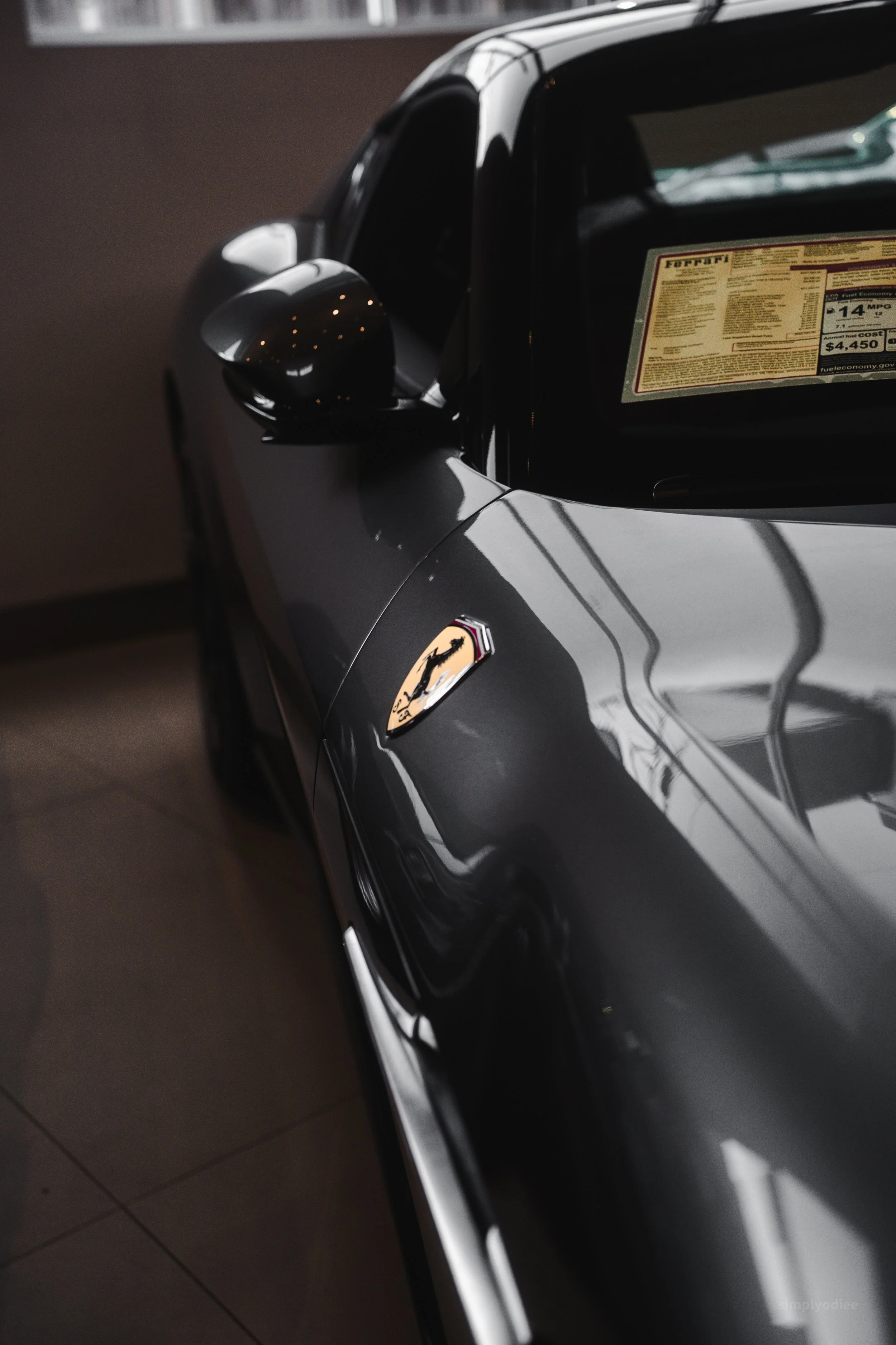Close-up of a black sports car with a Ferrari logo on the side