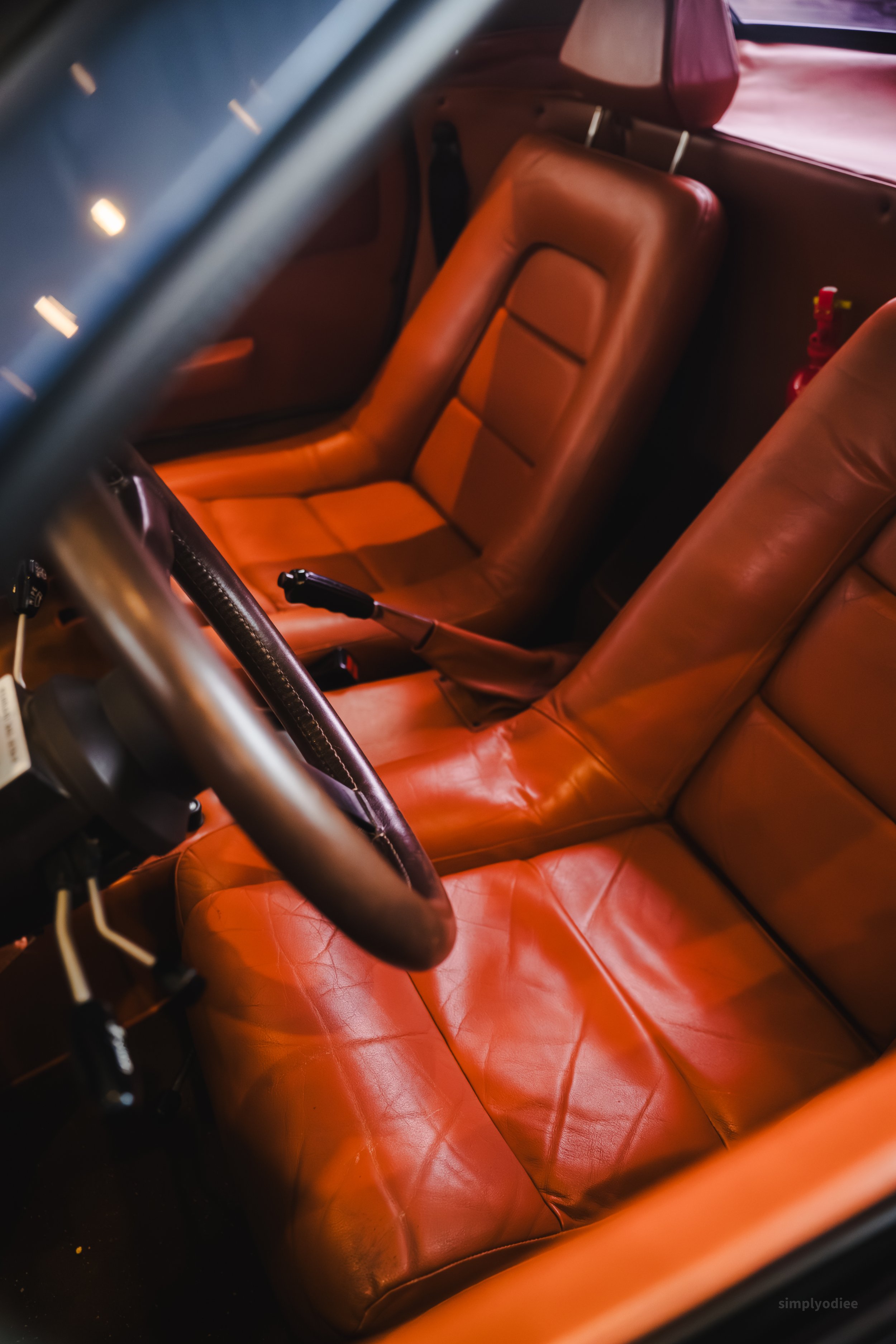 Two tan leather seats inside a vintage airplane cockpit with aircraft controls partially visible.