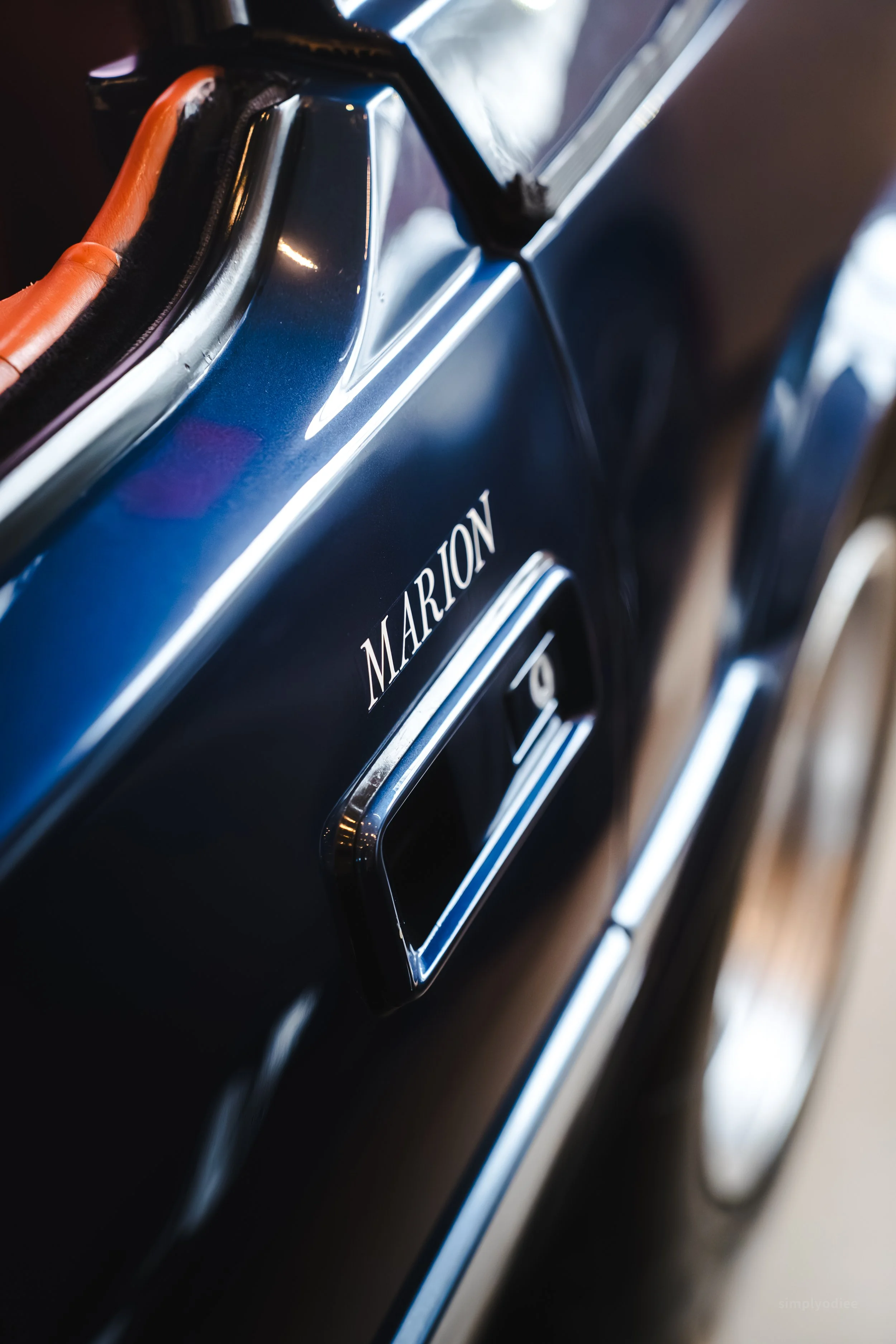 Close-up of a black washing machine with the brand name "Marion" and a silver control handle.