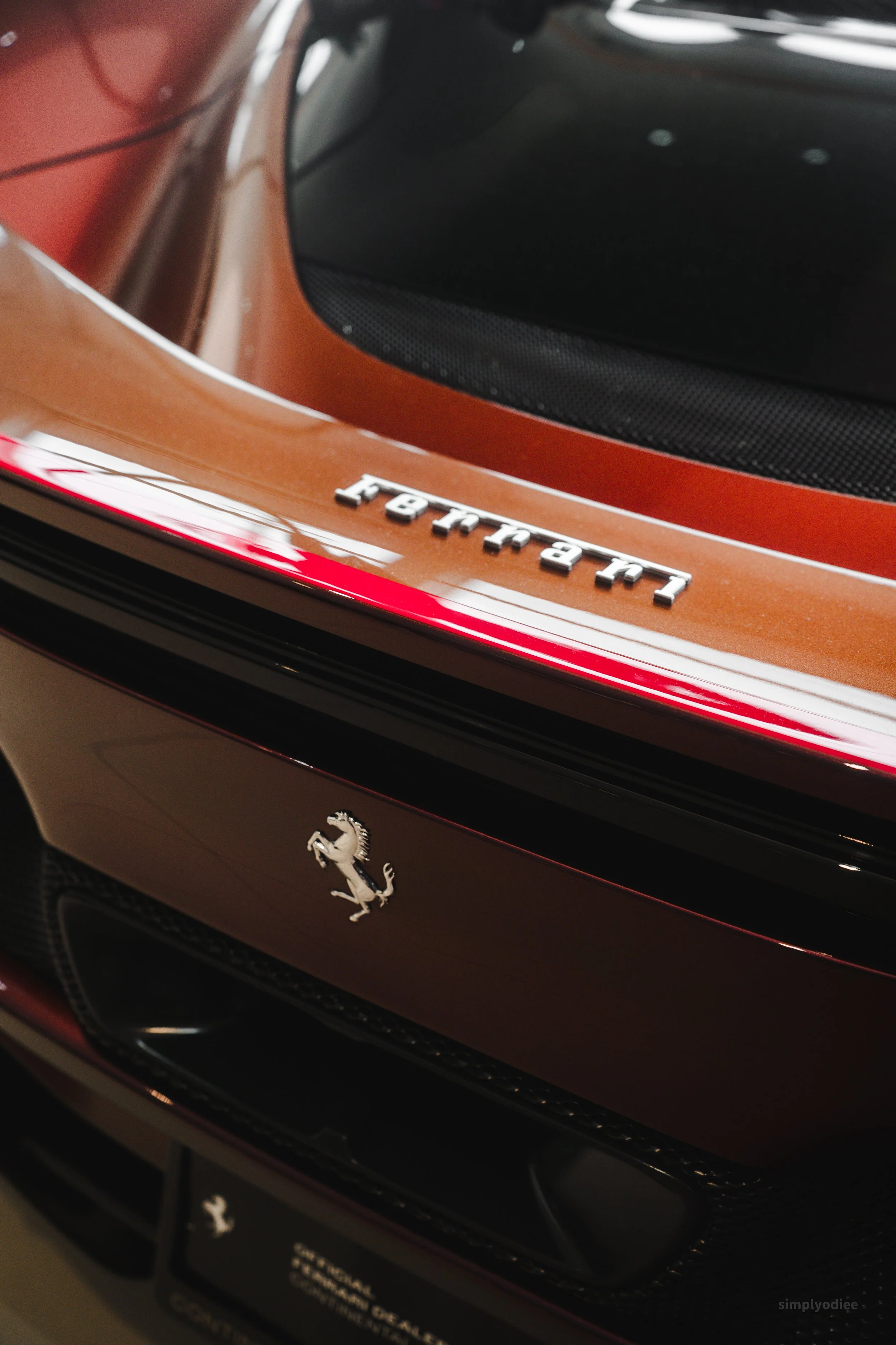 Close-up of the rear of a red Ferrari car, showing the Ferrari emblem and a model badge.