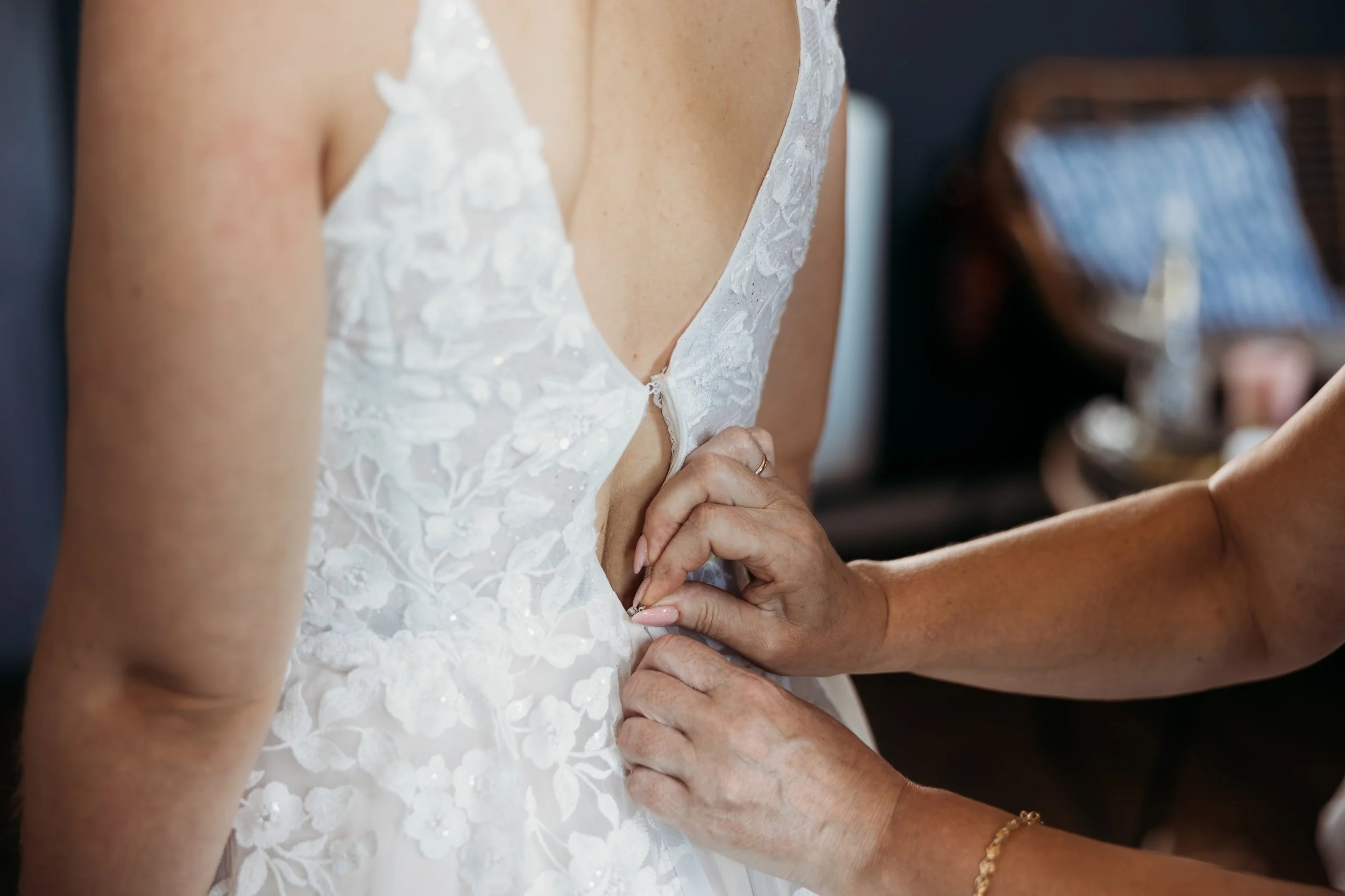 Braut zieht ihr Brautkleid Braut beim Getting Ready für ihre Hochzeit  auf Mathis Wiesenmühle an.