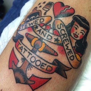 Tattoo of a woman with black hair, red lips, and a vintage style, surrounded by hearts, a banner with the words 'Stewed and Screwved', a whiskey bottle, and an anchoring rope.