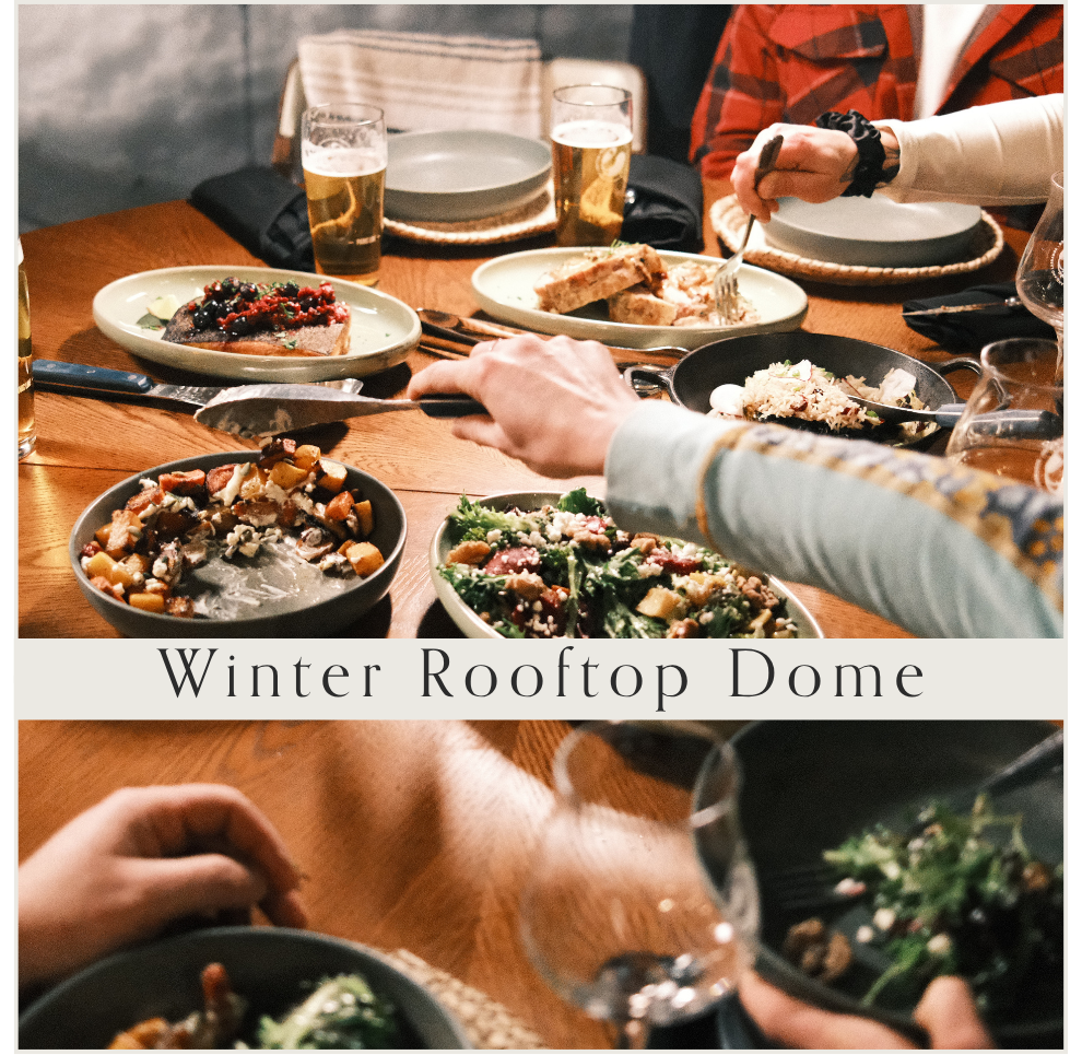 A dining table with plates of food, glasses of beer, and people serving themselves during a meal at a place called Winter Rooftop Dome.