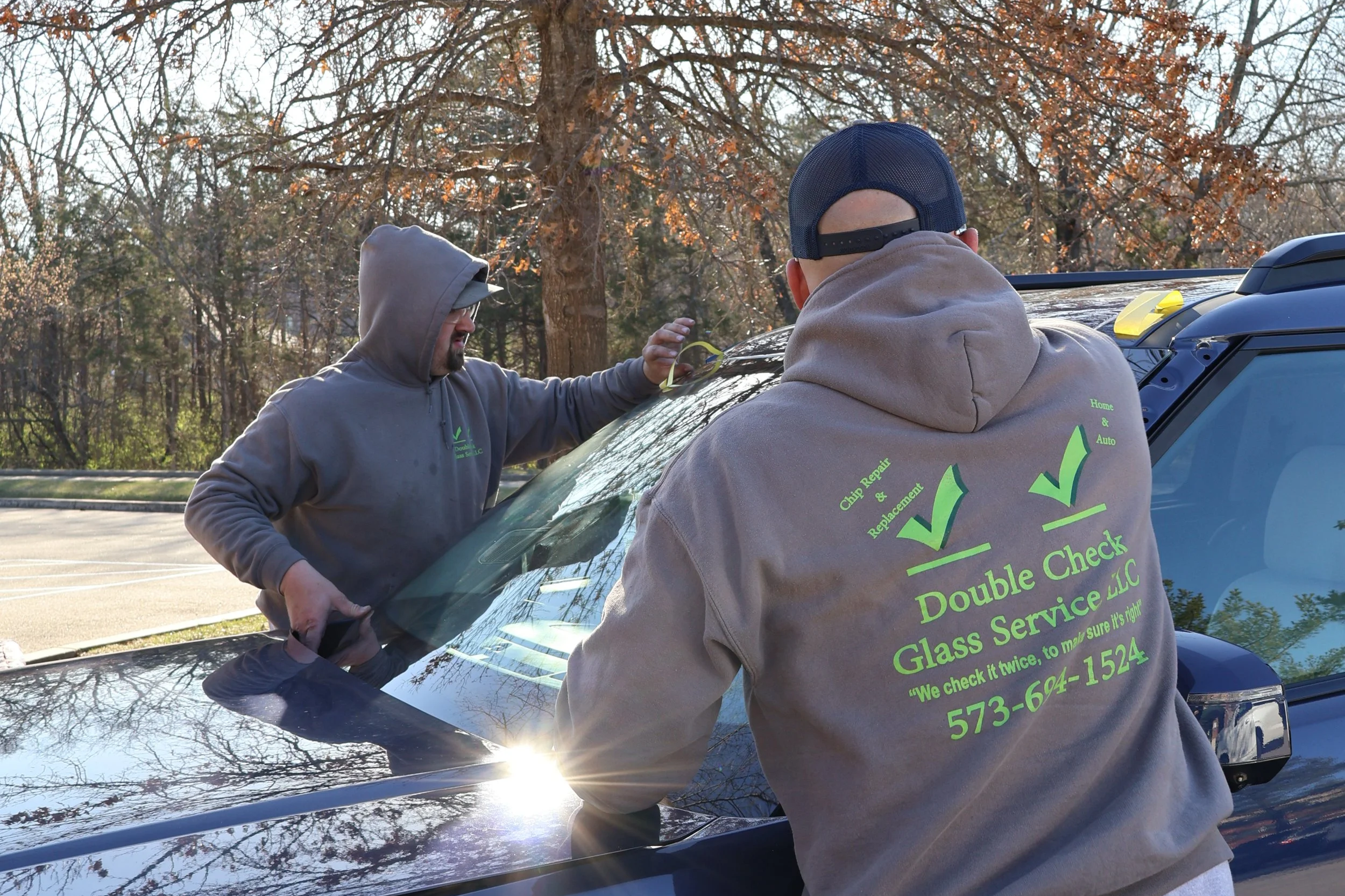 Glass repair technicians placing windshield
